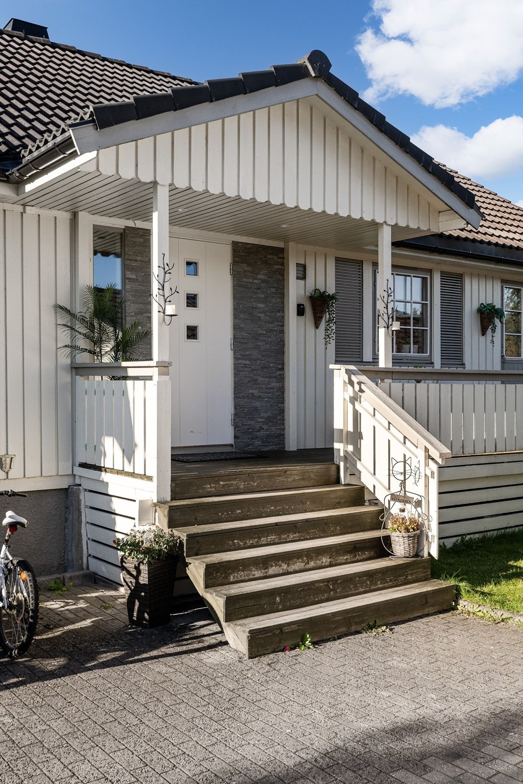 Et overbygget inngangsparti med detaljer i steinforblending ønsker deg velkommen hjem. Galleribilde