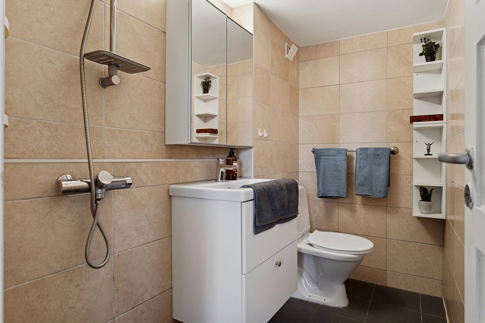 Flislagt bad oppusset i 2013 og har WC, åpen dusjplass, servant og varmekabler i gulv. Ny servant og blandebatteri(2024) Galleribilde