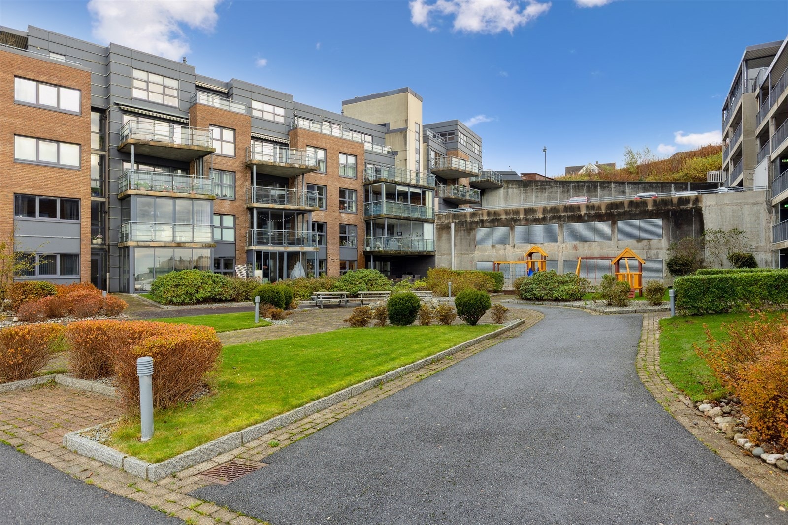 Felles tomt for sameiet. Flott opparbeidet og beplantet med bla lekeplass og hyggelig promenade i front. Galleribilde