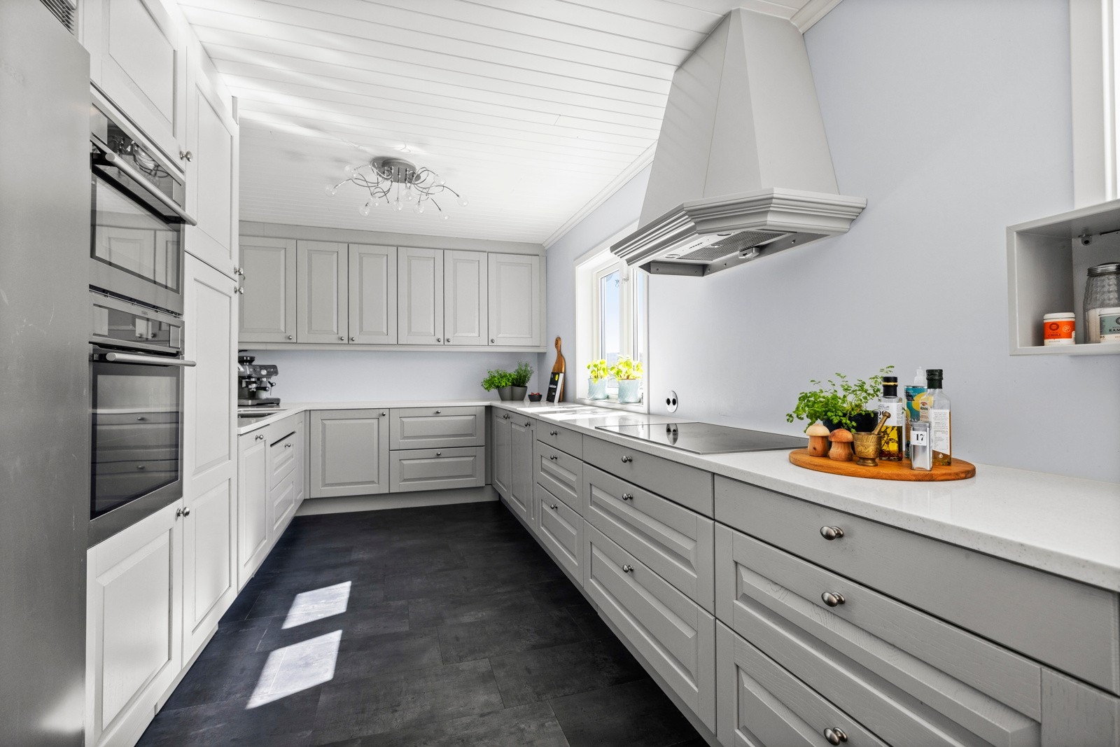 Det romslige kjøkkenet har kjøkkeninnredningen fra Sigdal som ble montert i 2018. Innredningen har barløsning, eik/malte fronter, Corian benkeplater, underlimt oppvaskkum, hetteventilator og belysning under overskap. Galleribilde