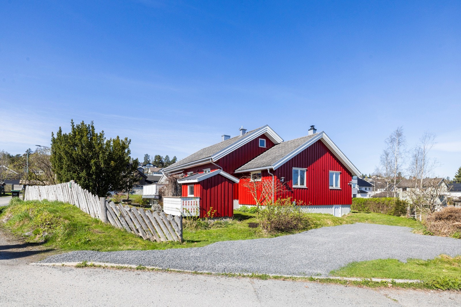 Tomt/fasade. Boligen har en ladeboks montert på ytterveggen for lading av el-bil. Galleribilde
