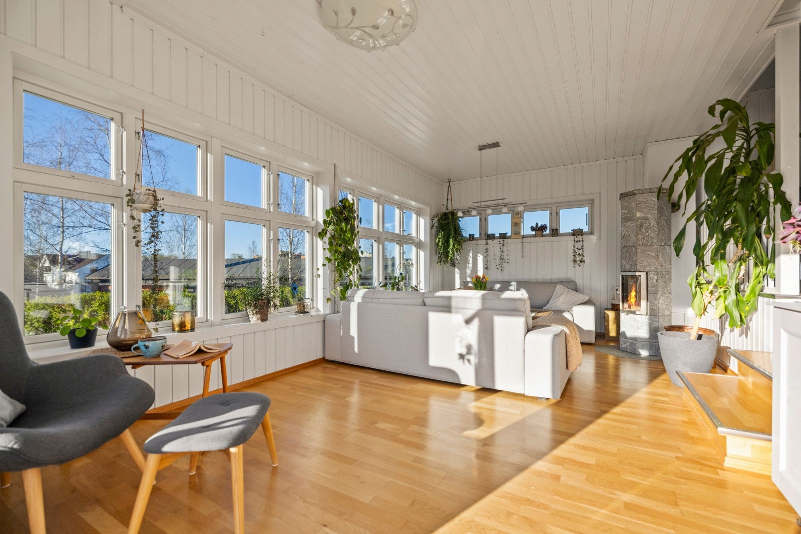 Stuen i 1. etasje har store vindusflater som gir mye naturlig lys. Stuen ligger noen trappetrinn ned fra tv-stuen. Galleribilde