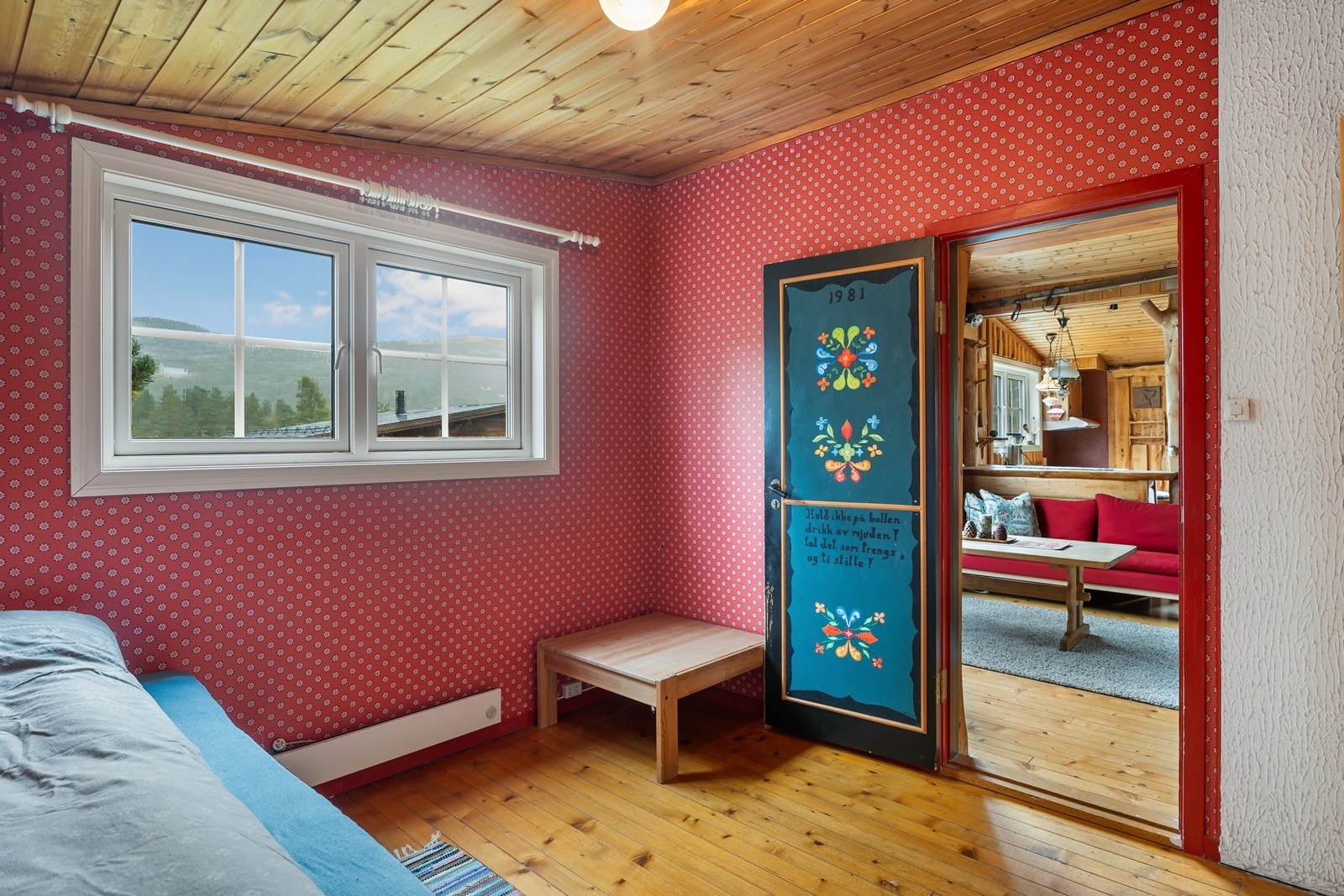 Soverom 2 med furugulv, panel i tak og tapet på vegger. Rommet har plass til dobbelseng Galleribilde