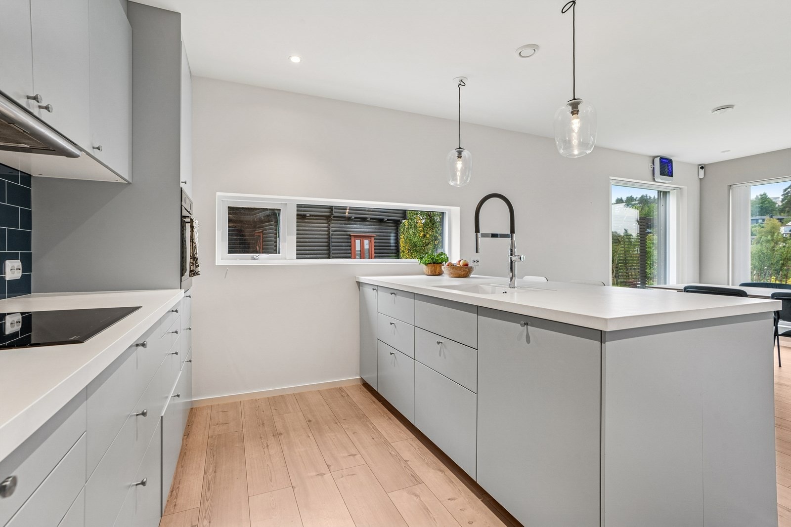 Kjøkkenet har integrerte hvitevarer og laminerte plater som backsplash over benkeplatene. Galleribilde