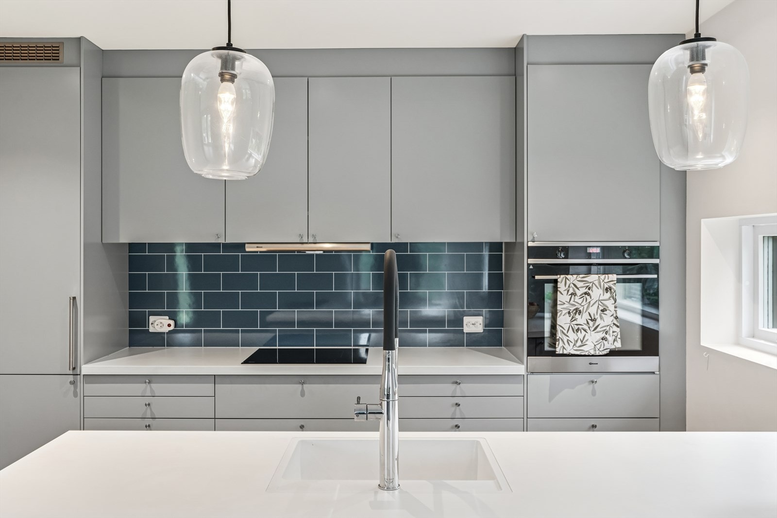 Kjøkkeninnredningen består av glatte fronter, kjøkkenøy og laminat benkeplate med nedfelt kum i kompositt og ettgrepsblandebatteri. Galleribilde