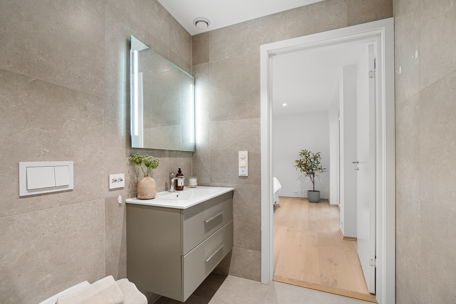 Fra soverommet er det inngang til lekkert flislagt bad med vegghengt toalett og servant med oppbevaring. Galleribilde