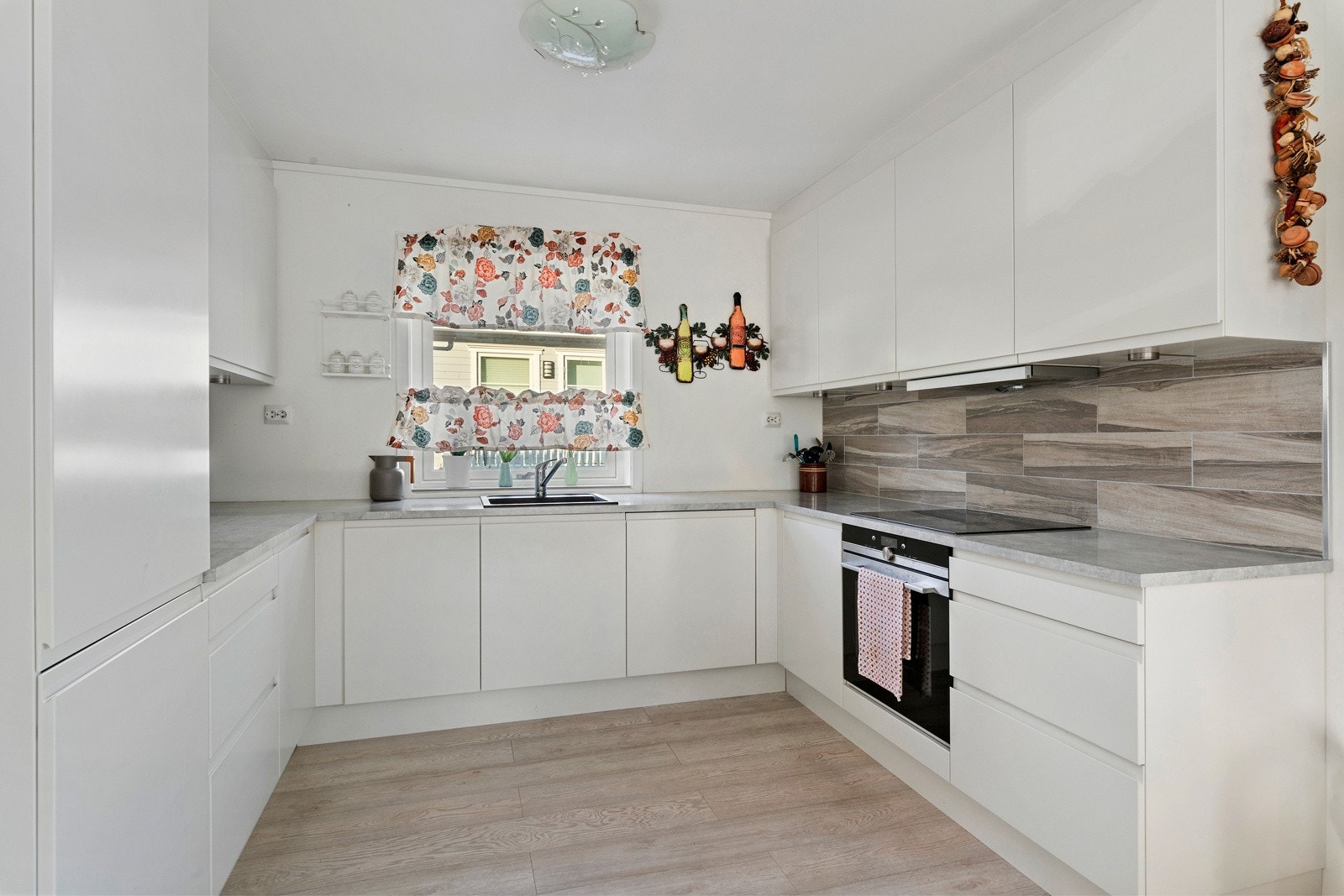 Silren kjøkkeninnredning med mye skap- og benkeplass, integrerte hvitevarer medfølger. Galleribilde