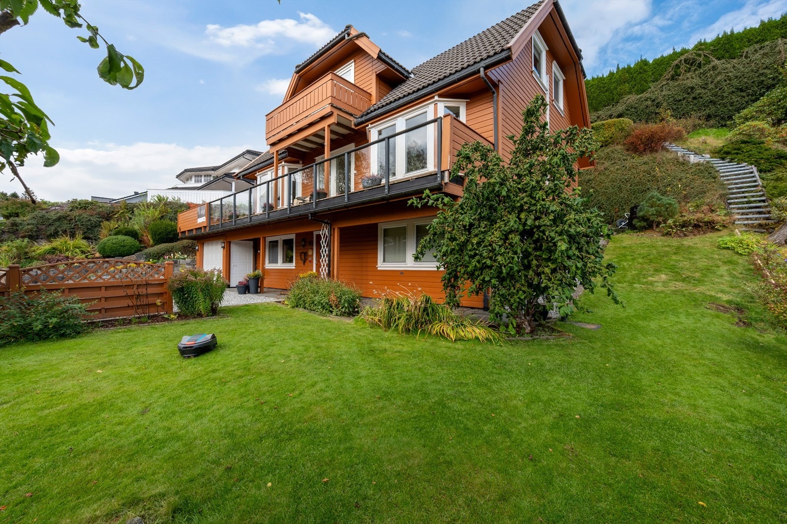 Stor og velstelt hage med flott beplantning og grønn plen. Galleribilde