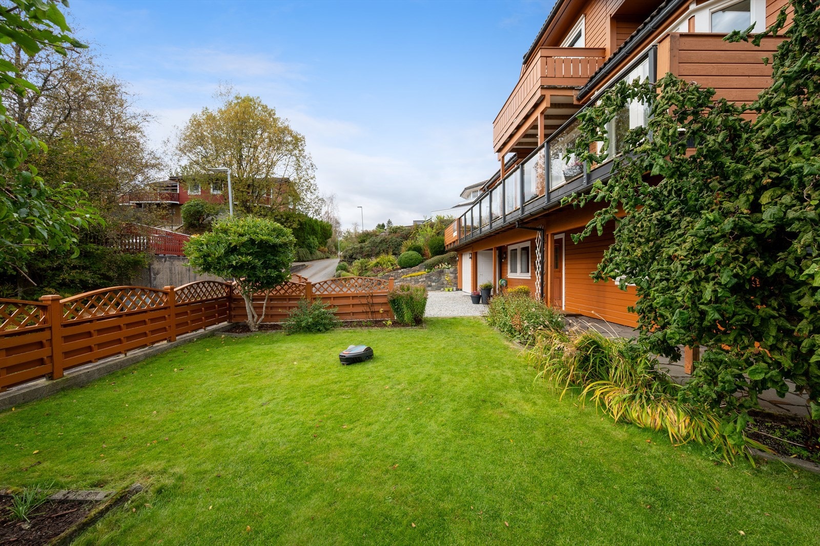 Du møtes av en velstelt eiendom med flotte utearealer som er pent opparbeidet med planter, bed, prydebusker samt grønn plen som er perfekt for lek og ballspill. Galleribilde