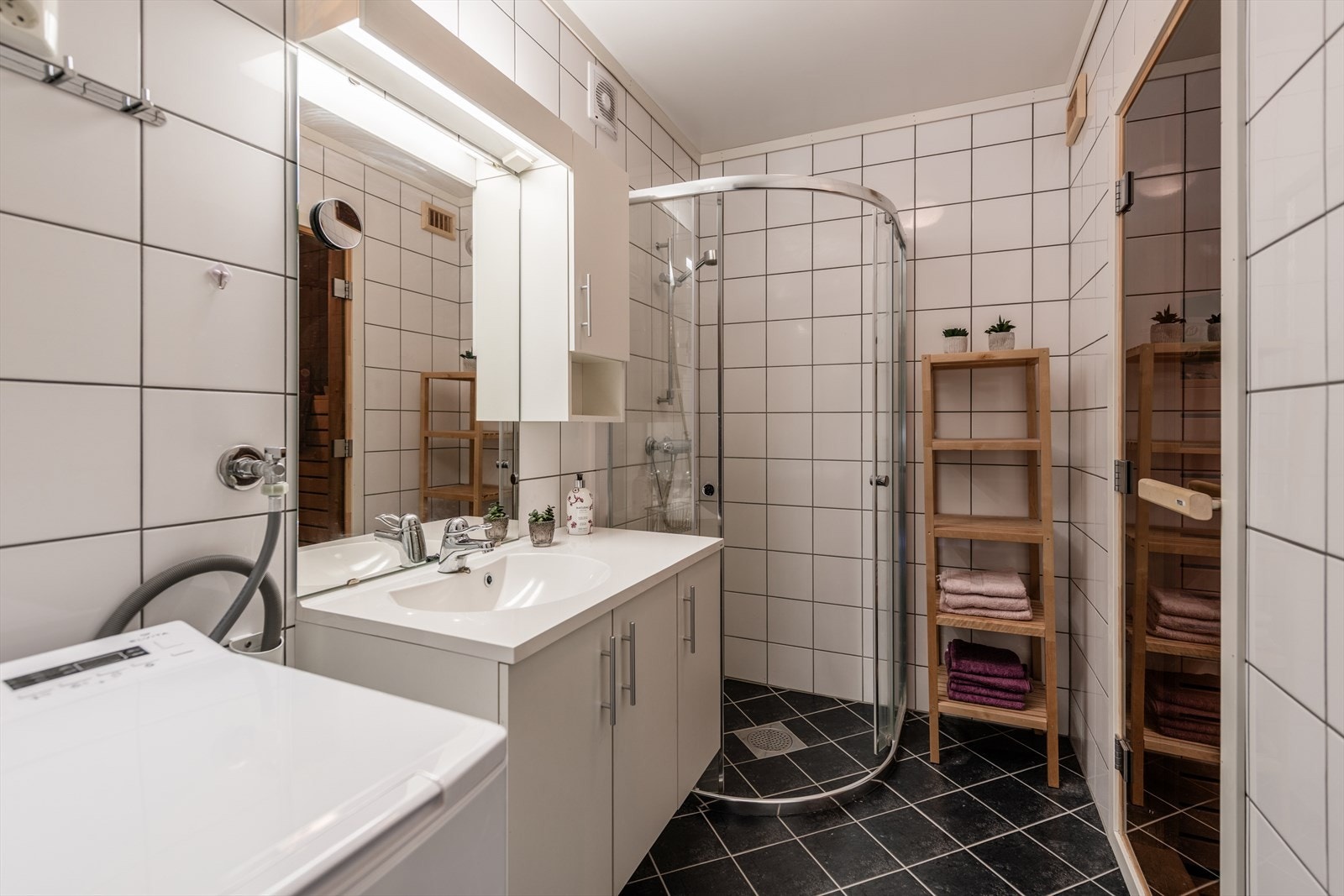 Bad med servant, dusjvegger og opplegg for vaskemaskin, samt tilgang til badstuen - det perfekte sted for avkobling etter en lang dag ute! Galleribilde