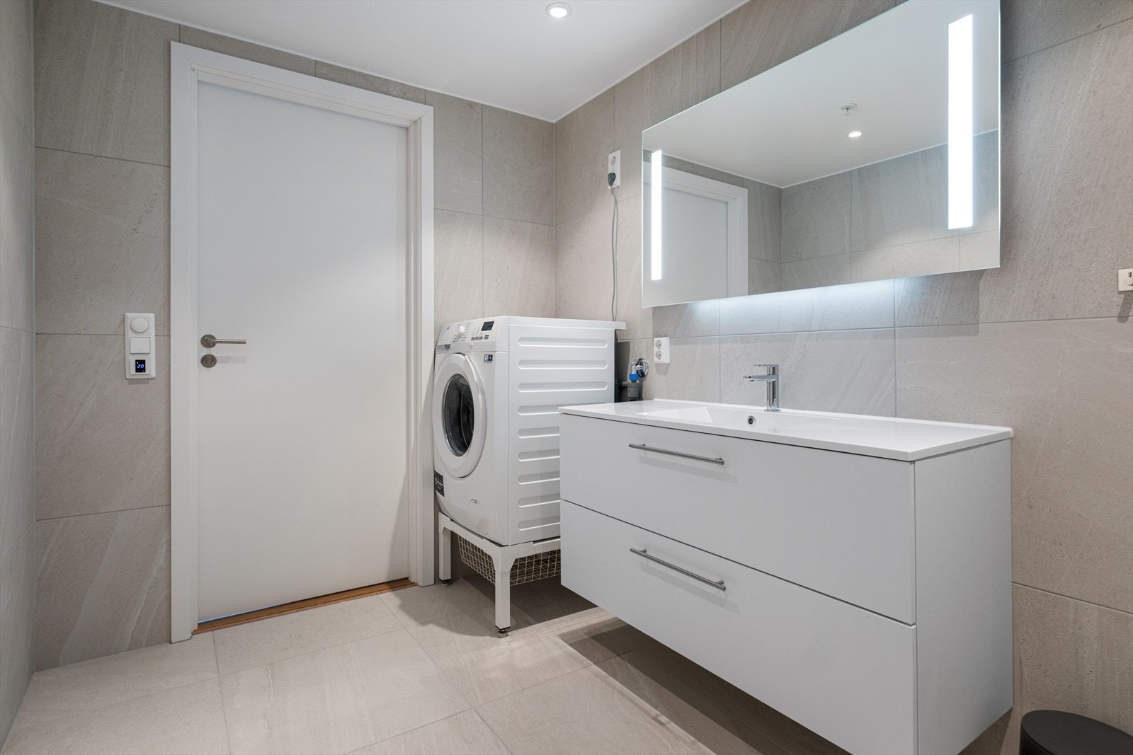 Opplegg for vaskemaskin og helstøpt kompositt servantplate gir funksjonelt vaskerom. Galleribilde