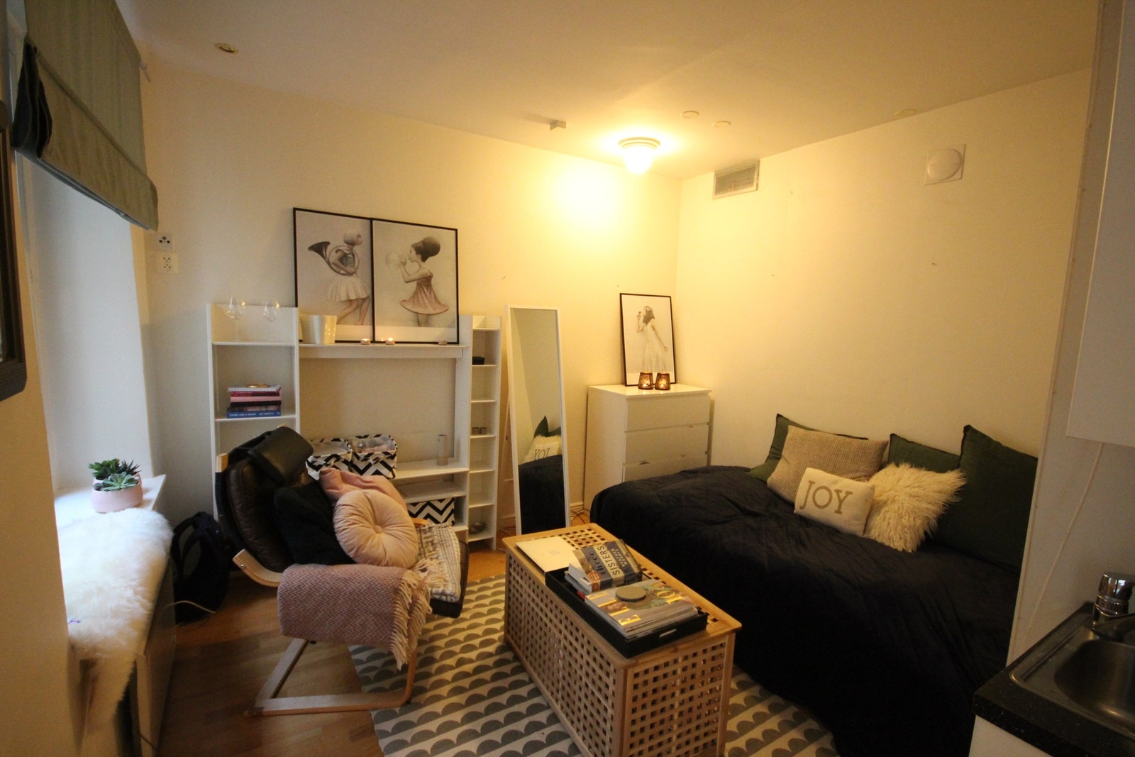 Koselig stue med seng og store vindusflater Galleribilde