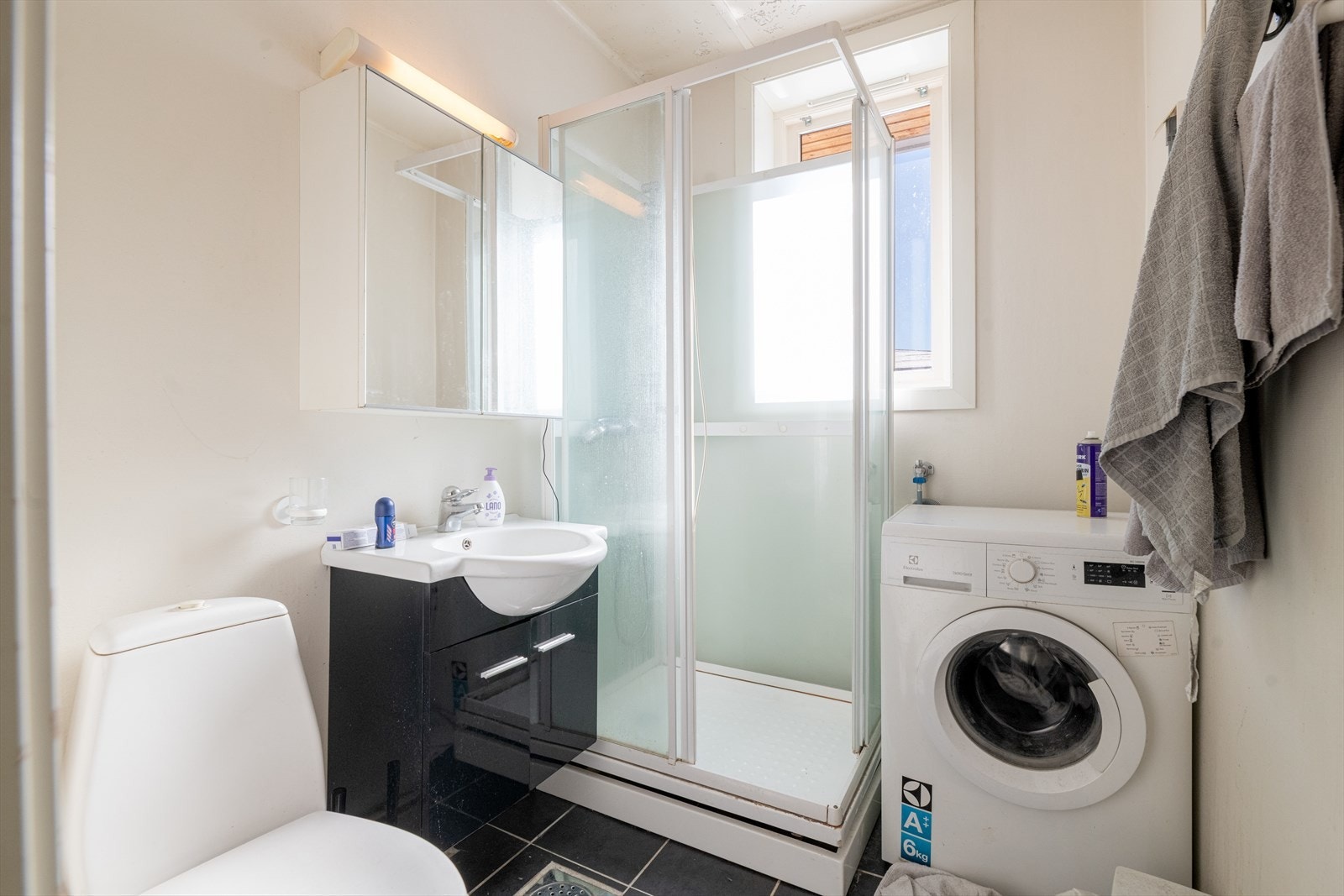 Baderommet innehar dusjkabinett, servantinnredning og toalett. Det er opplegg for vaskemaskin. Galleribilde