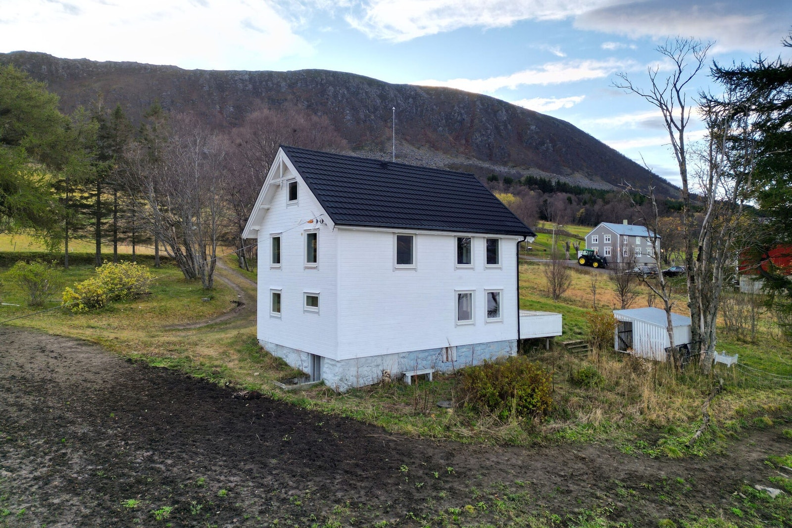 Rundt boligen er tomten opparbeidet med plen, trær og beplantning. Innkjøring og gårdsplass med grus/singel. Galleribilde