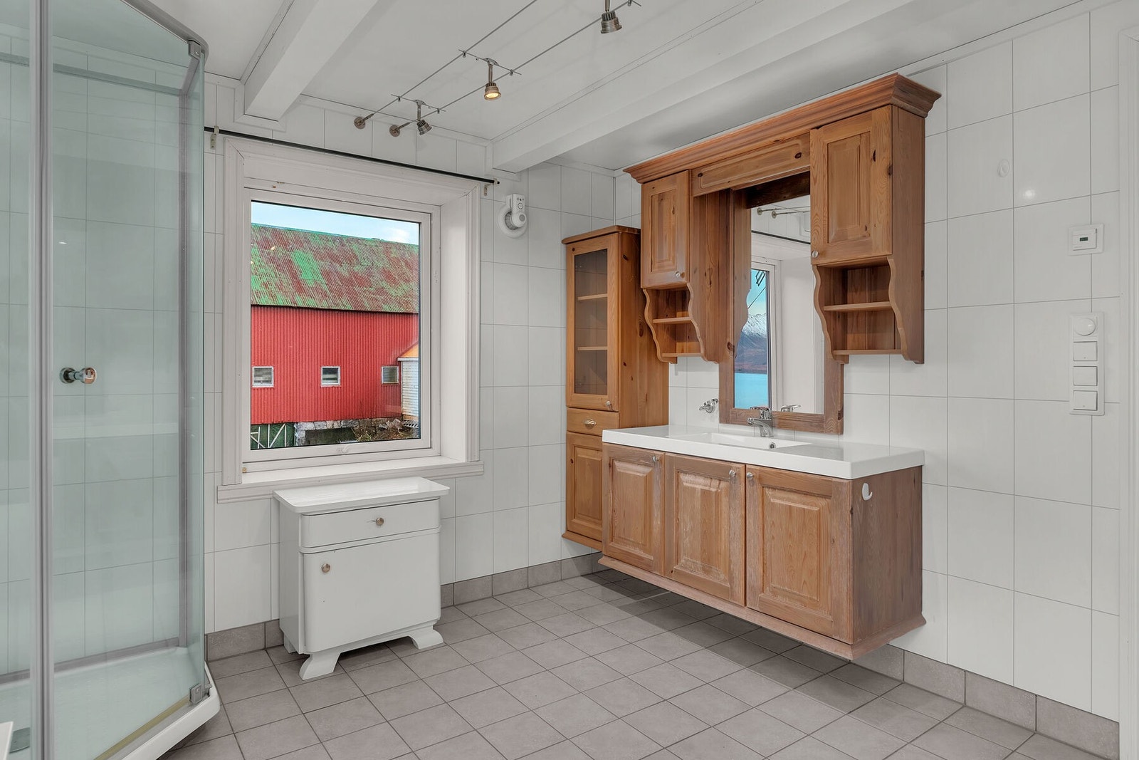 Badet har servant på innredning, dusjkabinett, toalett og opplegg for vaskemaskin. Galleribilde