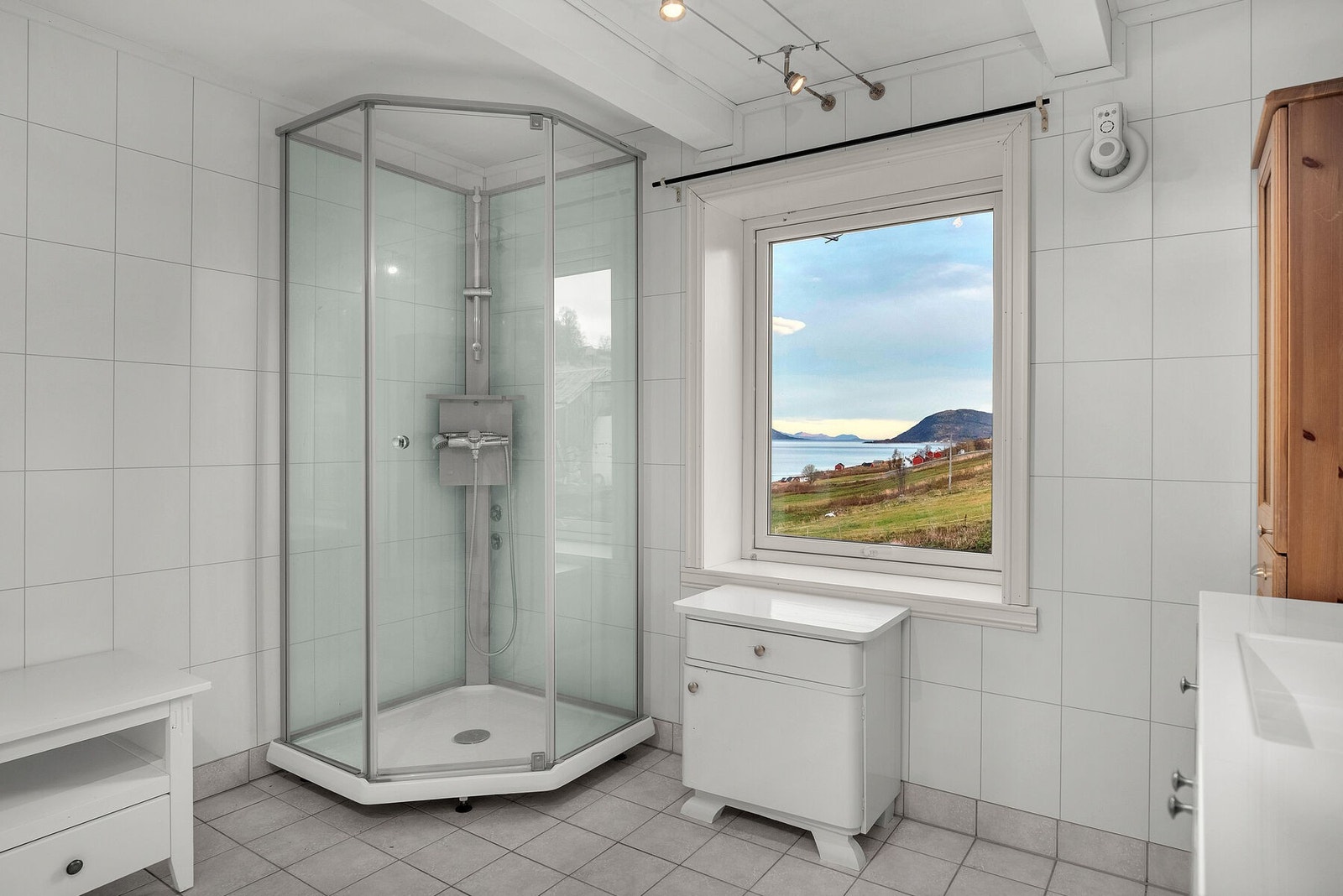 Badet er utført med flislagt gulv med elektriske varmekabler, baderomsplater på veggene og malt tak. Galleribilde