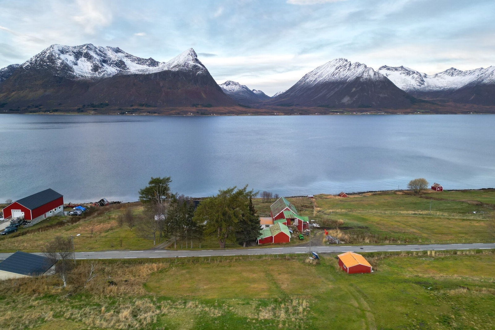 Solåpen eiendom med hovedfasade mot sør og vest, med fri og meget god utsikt mot sjø og fjell. Eiendommen strekker seg over begge sider av offentlig vei og grenser til sjø. Galleribilde