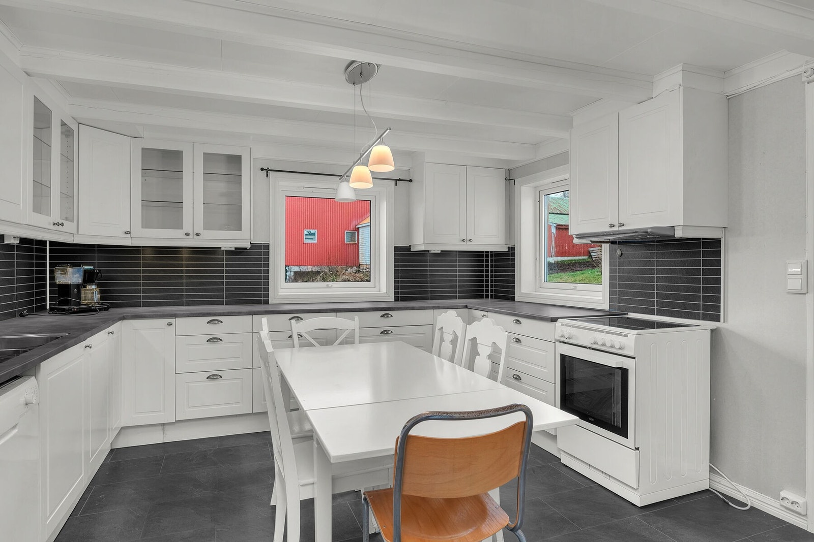 Klassisk, lyst kjøkken med profilerte fronter og opplegg for frittstående hvitevarer. Galleribilde