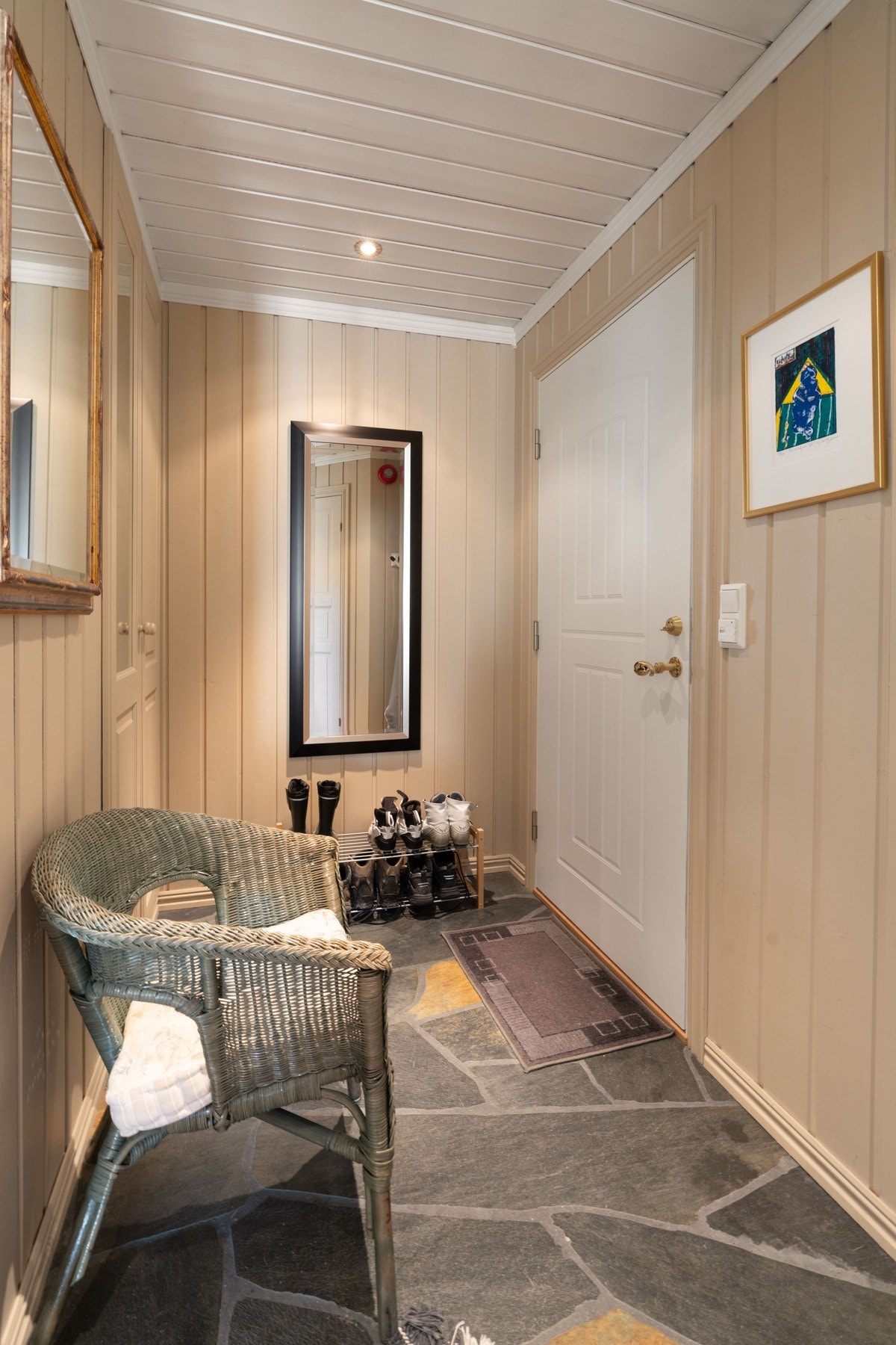 Romslig entrè med garderobeskap og skiferlagt gulv med varmekabler. Galleribilde