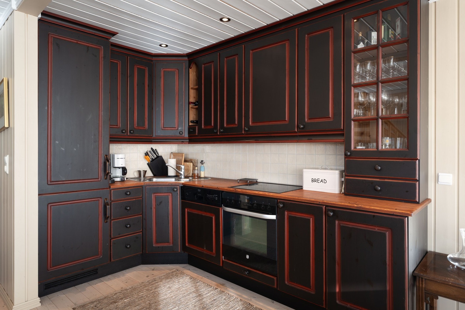 Stilrent kjøkken med heltre benkeplate og integrerte hvitevarer. Galleribilde