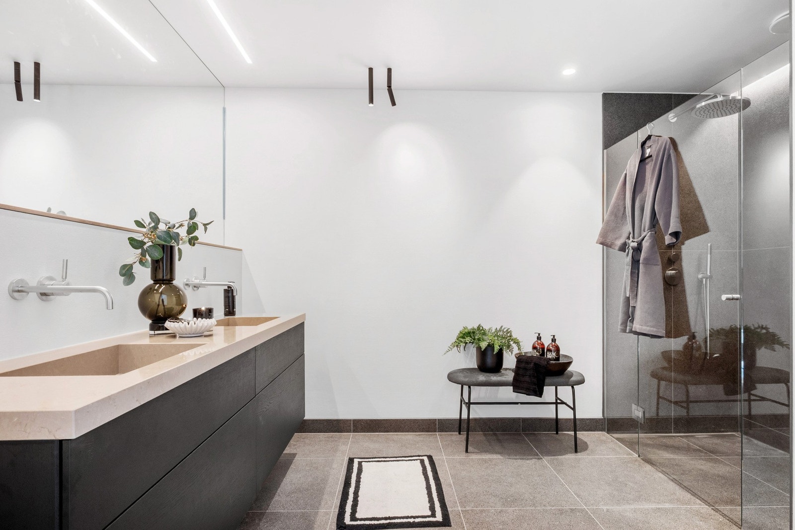 Badet i tilknytning til hovedsoverommet er utstyrt med bl.a Poliform innredning, integrert dobbel servant, benkeplate i steinkompositt og hellimt speil over vasken