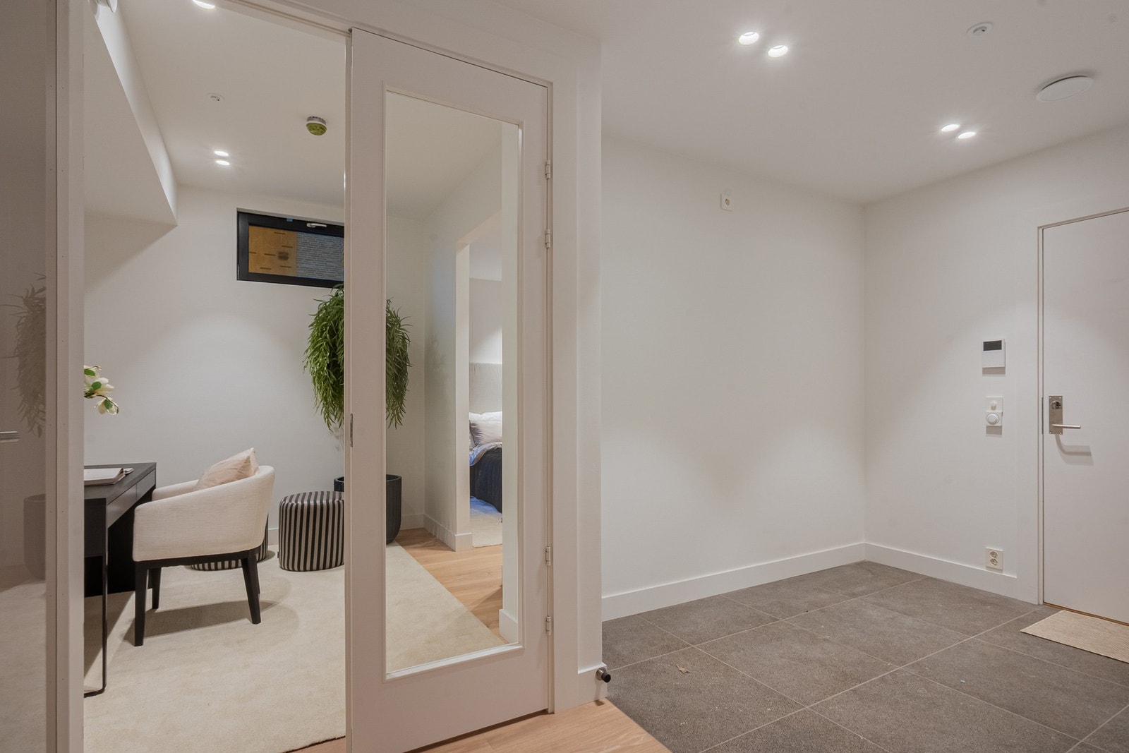 Flislagt del av entrè, gjør det enkelt å holde arealet rent. Avsatt plass til garderobeskap i nisjen til venstre i gangen. La oss ta turen ned og inn i fellesarealene.