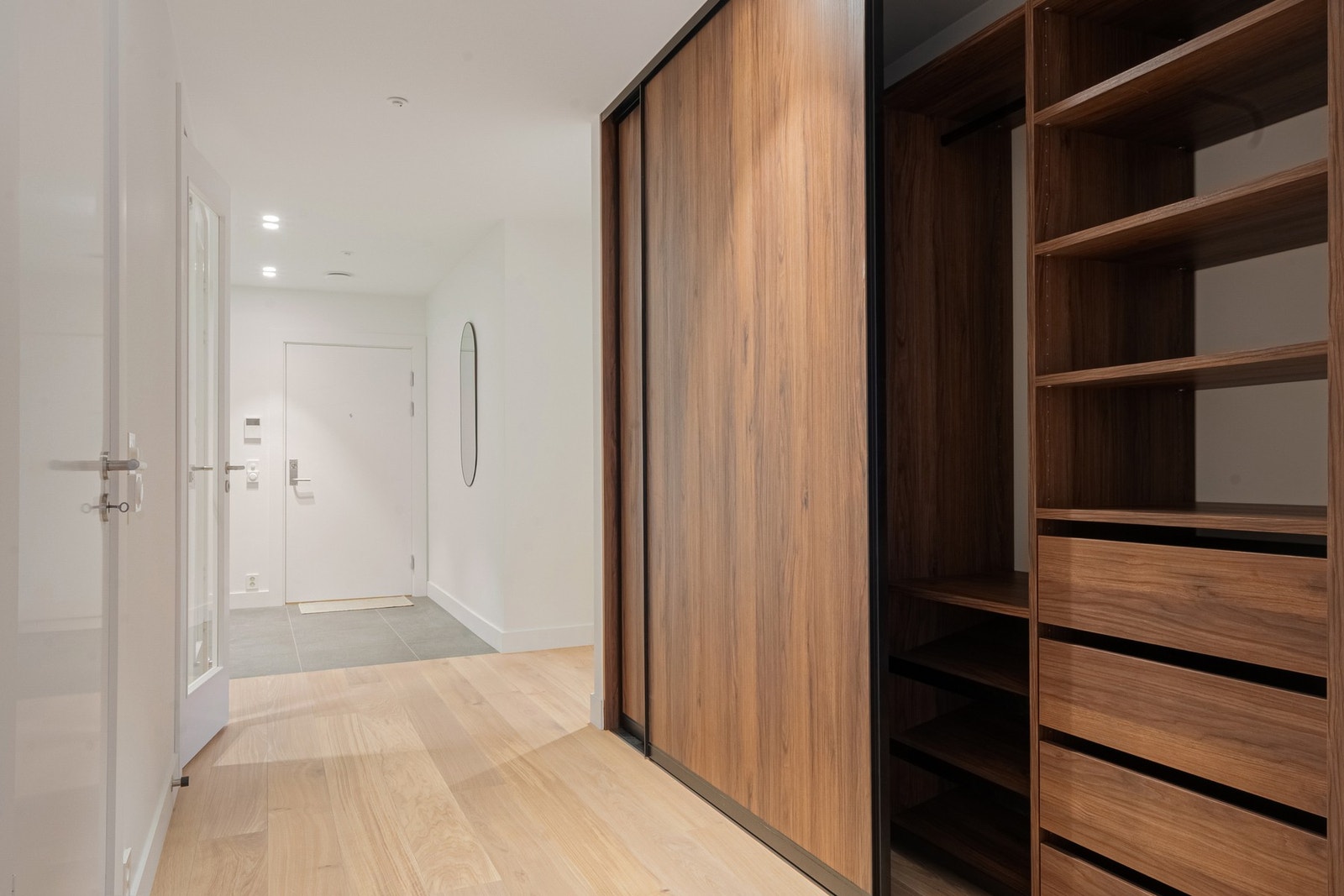 Stor, innholdsrik skyvedørsgarderobe i entrèen