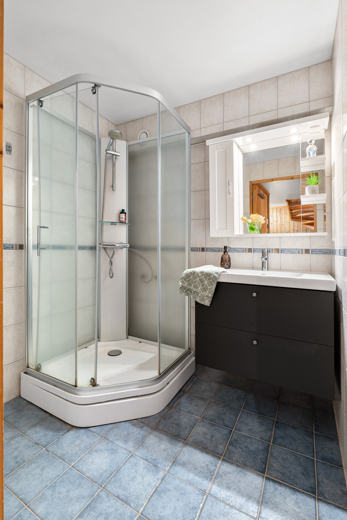 Flislagt bad med dusjkabinett og servant i skap. Galleribilde