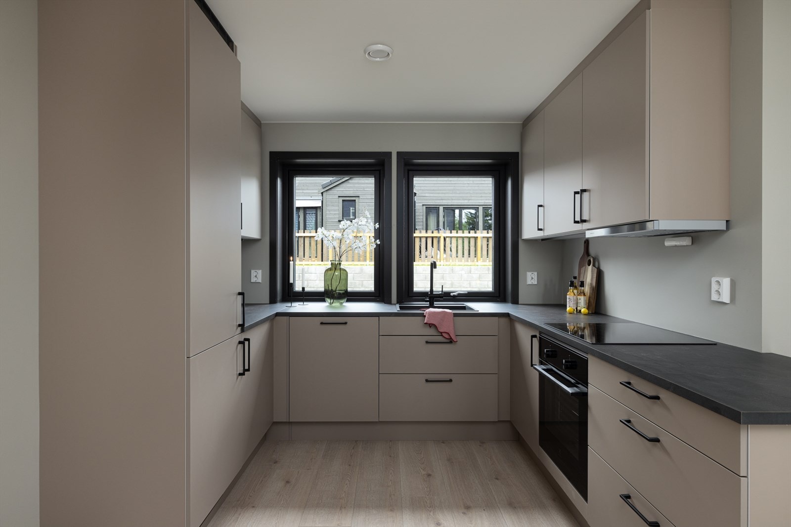 Fint kjøkken med glatte fronter og integrerte hvitevarer. Galleribilde