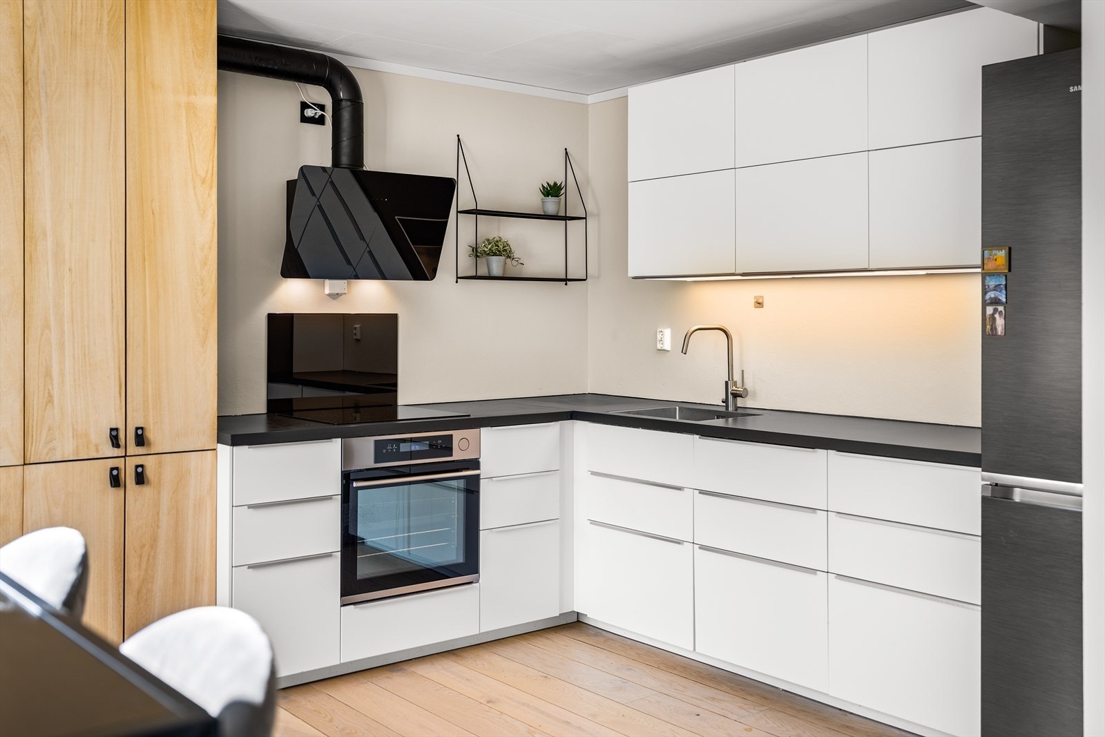 Pen kjøkkeninnredning i glatt utførelse med godt med skap- og benkeplass Galleribilde