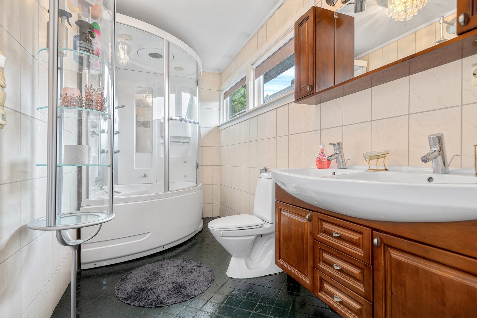 Bad med flislagte overflater. Innredet med dobelservant, toalett og romslig dusjkabinett m/badekar Galleribilde