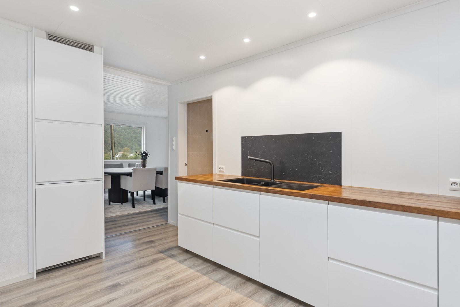 Benkeplaten er nylig pusset ned og behandlet. Oppvaskmaskin er praktisk plassert ved vask, og kjøleskap + frys til venstre Galleribilde