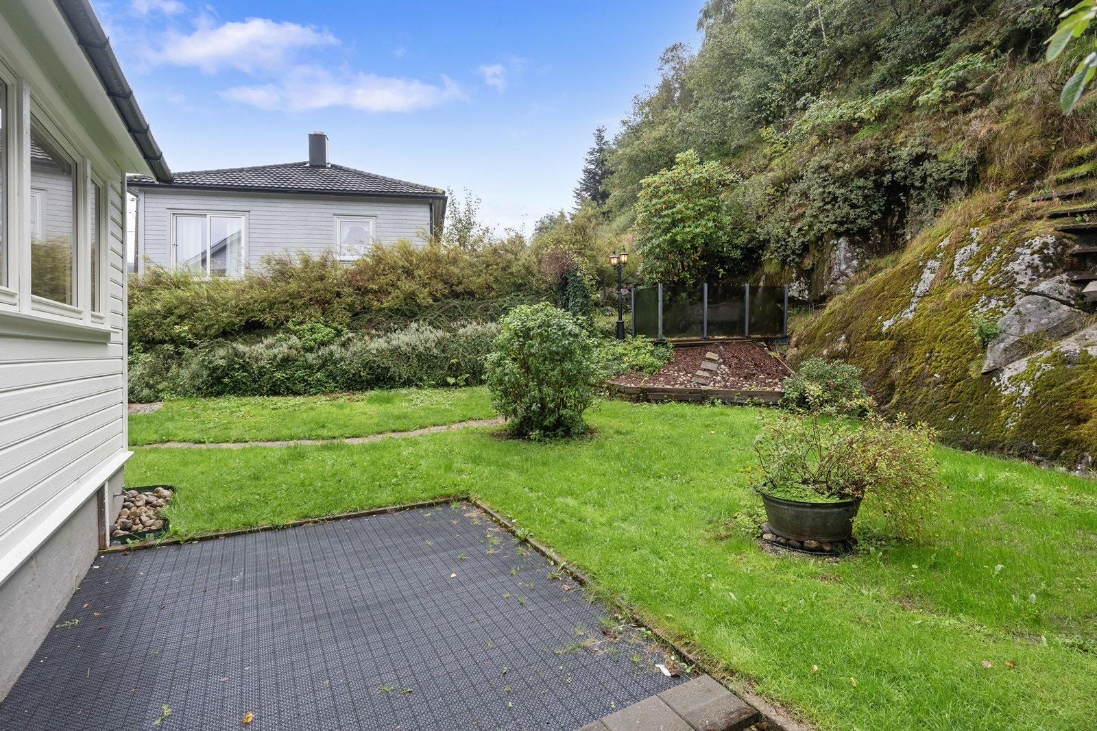 Hagen er idag lettstelt og enkelt opparbeidet. Her er plass til sittegruppe nede ved boligen samt i hjørnet av tomten hvor det er laget platting. Galleribilde