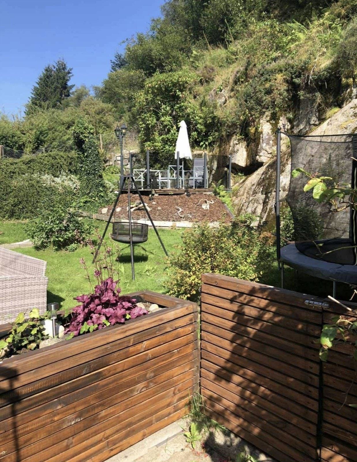 Private bilder som viser hagen litt mer frodig sommerstid når selger selv bodde i boligen. Galleribilde