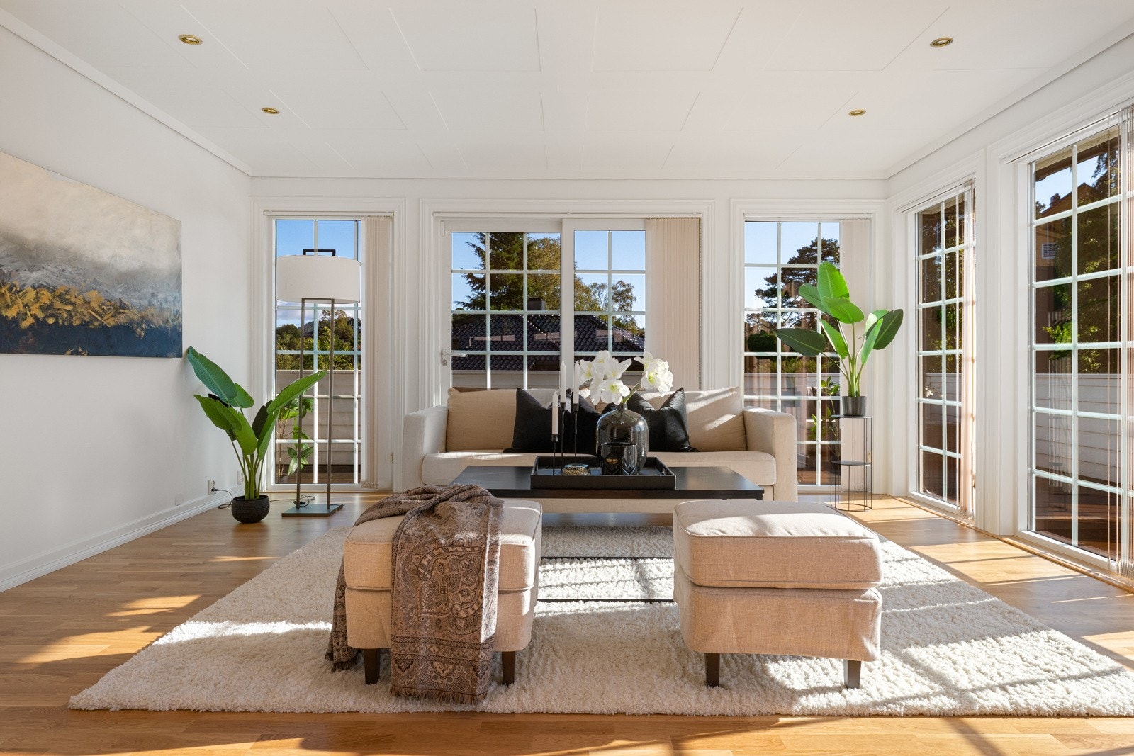 Store vindusflater langs hele veggen sørger for rikelig med dagslys som fyller stuen Galleribilde