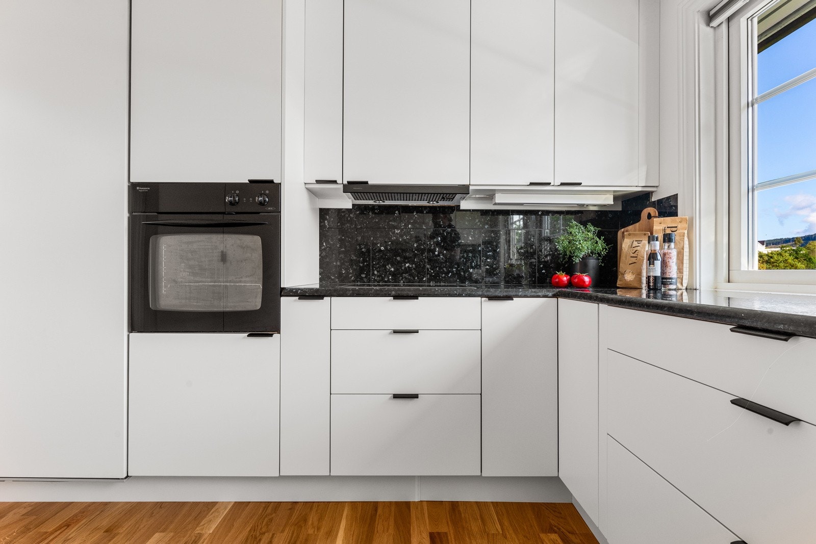 Integrerte hvitevarer er induksjonsplatetopp, kjøleskap, stekeovn og oppvasksmaskin Galleribilde