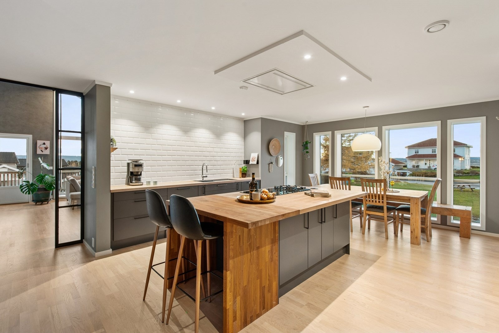 Lekkert og innholdsrikt kjøkken med kjøkkenøy og spiseplass. Galleribilde