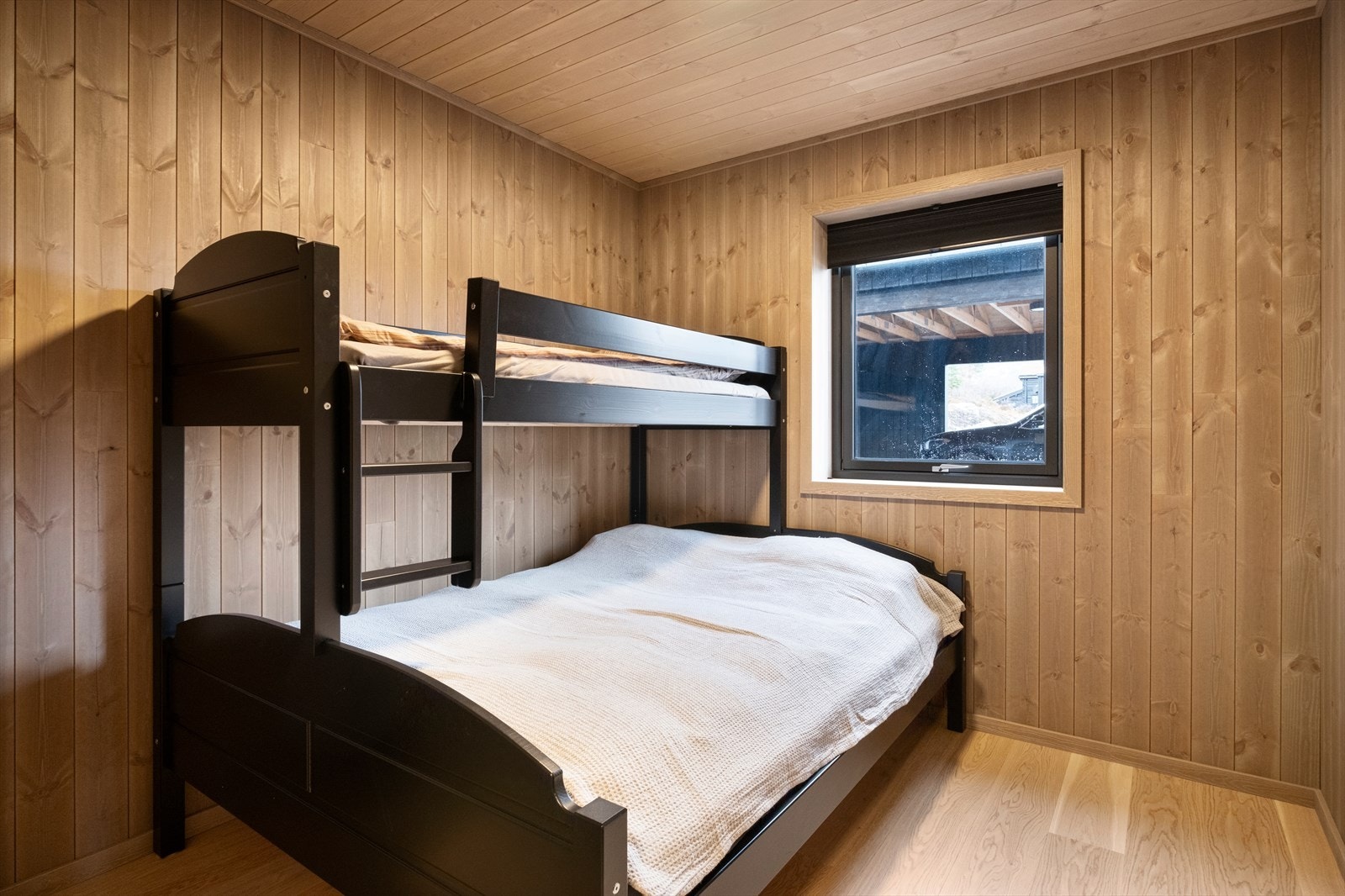 Panelvegger og parkettgulv gir et varmt og naturlig uttrykk i rommet. Vinduet har trelags energiglass som sikrer god isolasjon. Galleribilde