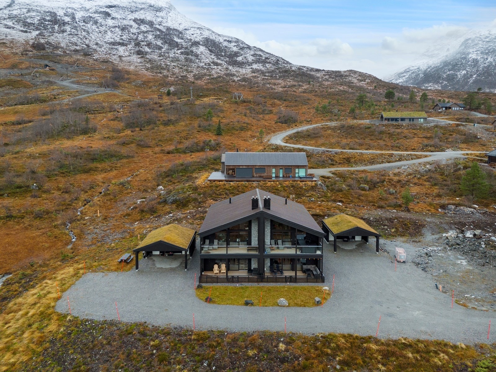 Boligen har en praktisk carport med trekonstruksjon og gresskledd tak. Galleribilde