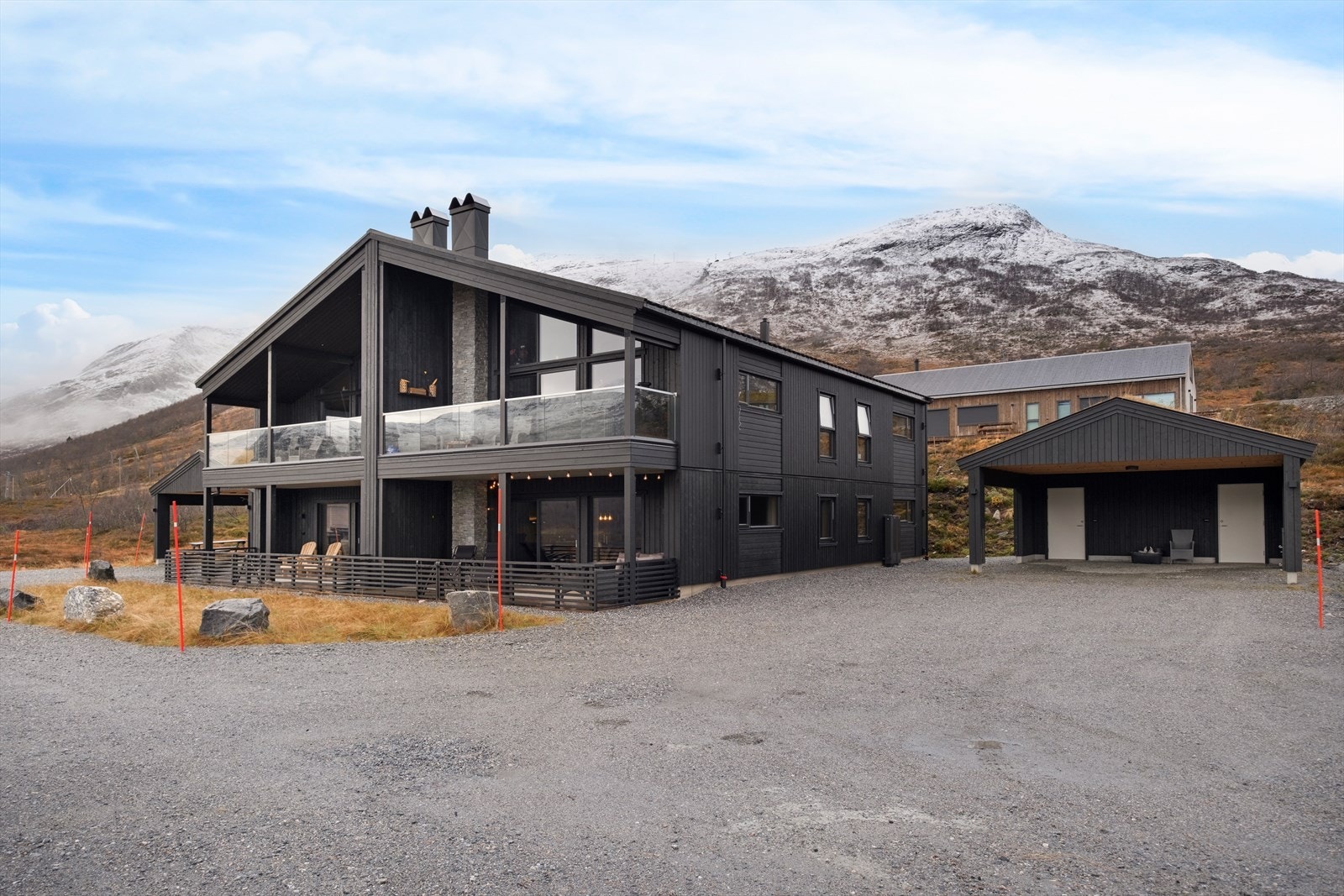 Gruset innkjørsel og biloppstillingsplass er opparbeidet på eiendommen, som ligger i relativt flatt terreng (kilde: tilstandsrapport). Galleribilde