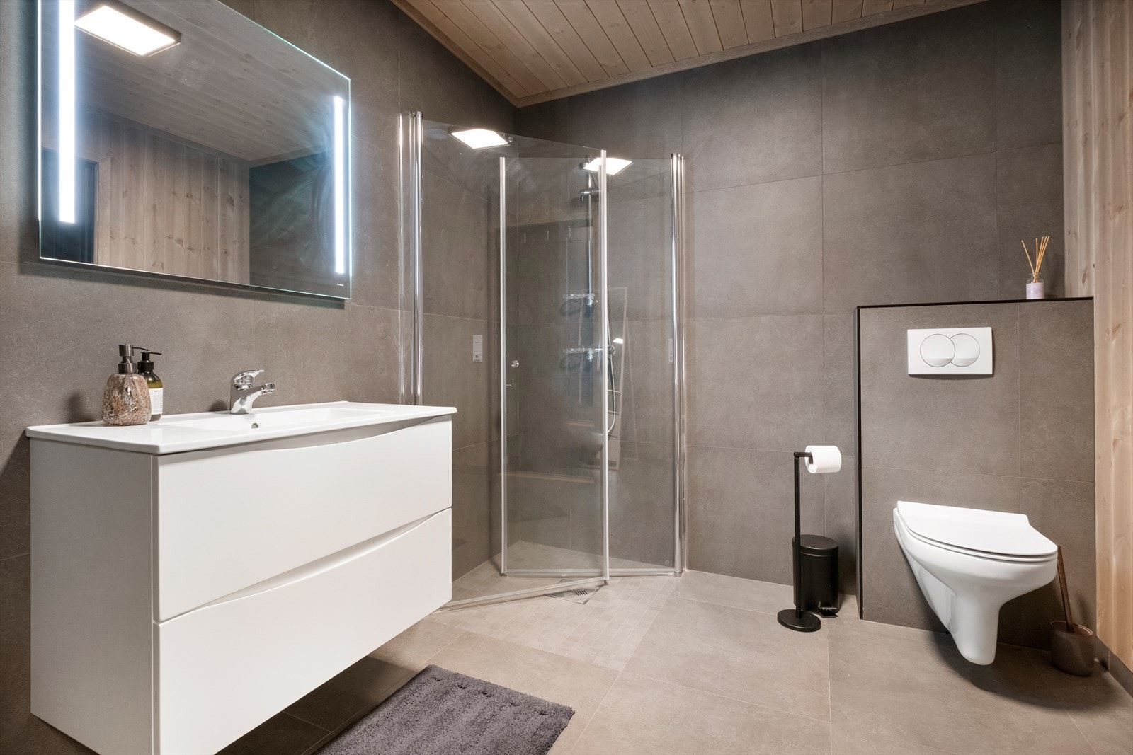 Vegghengt toalett og dusjhjørne med glassdører gir effektive løsninger på badet. Galleribilde