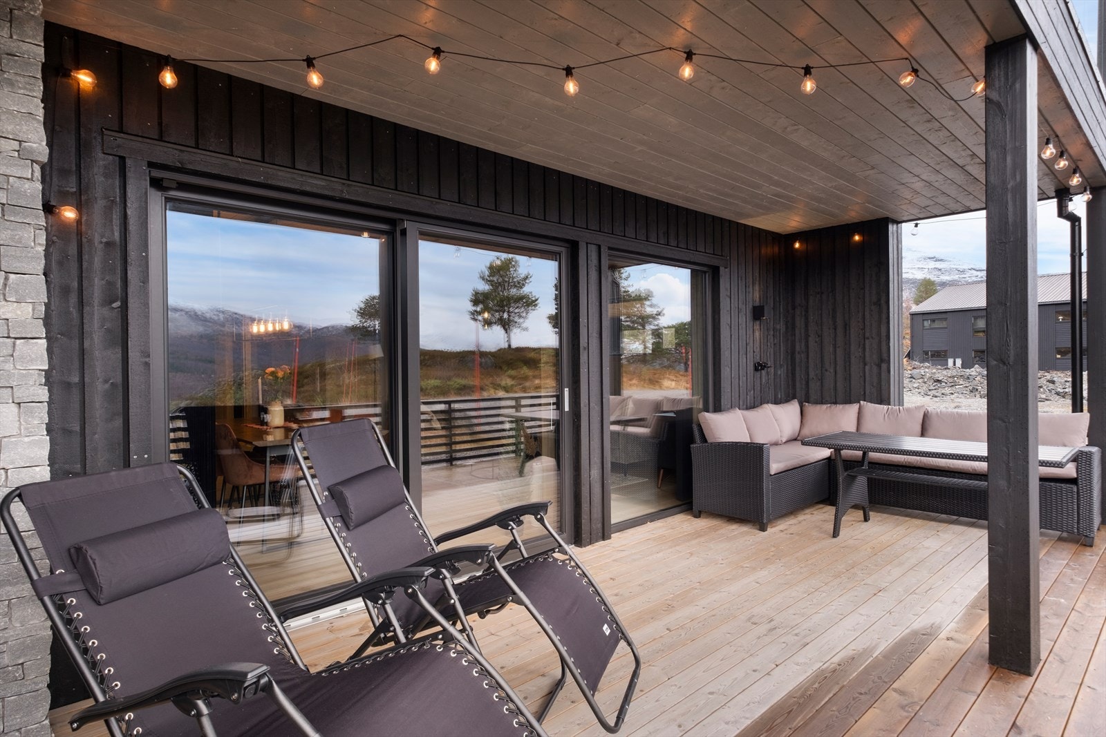 Terrassen har levegger av treverk og gir utsikt mot naturtomt. Galleribilde