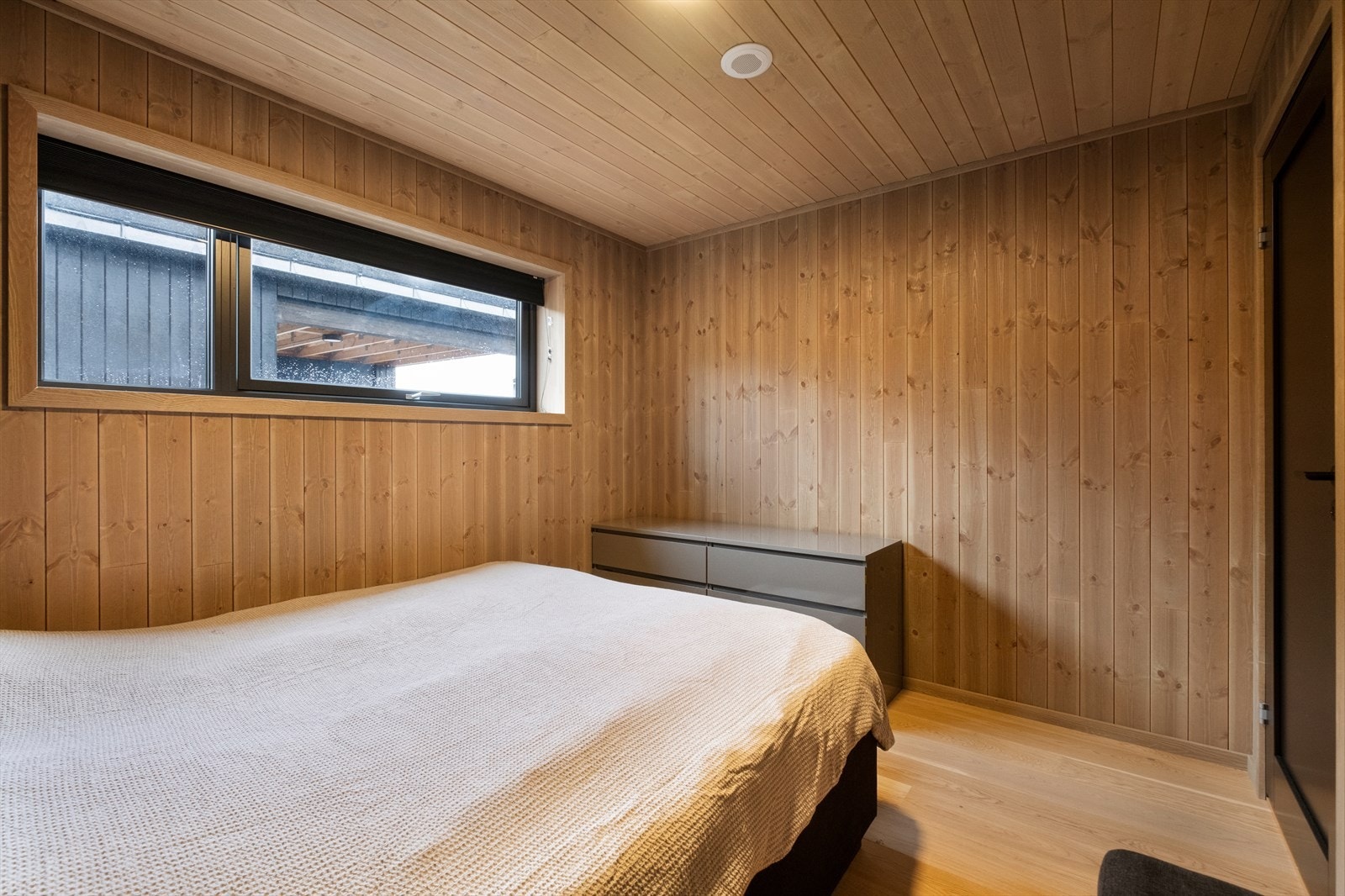 Plass til dobbeltseng og oppbevaringsmøbler gjør rommet praktisk for overnatting. Galleribilde