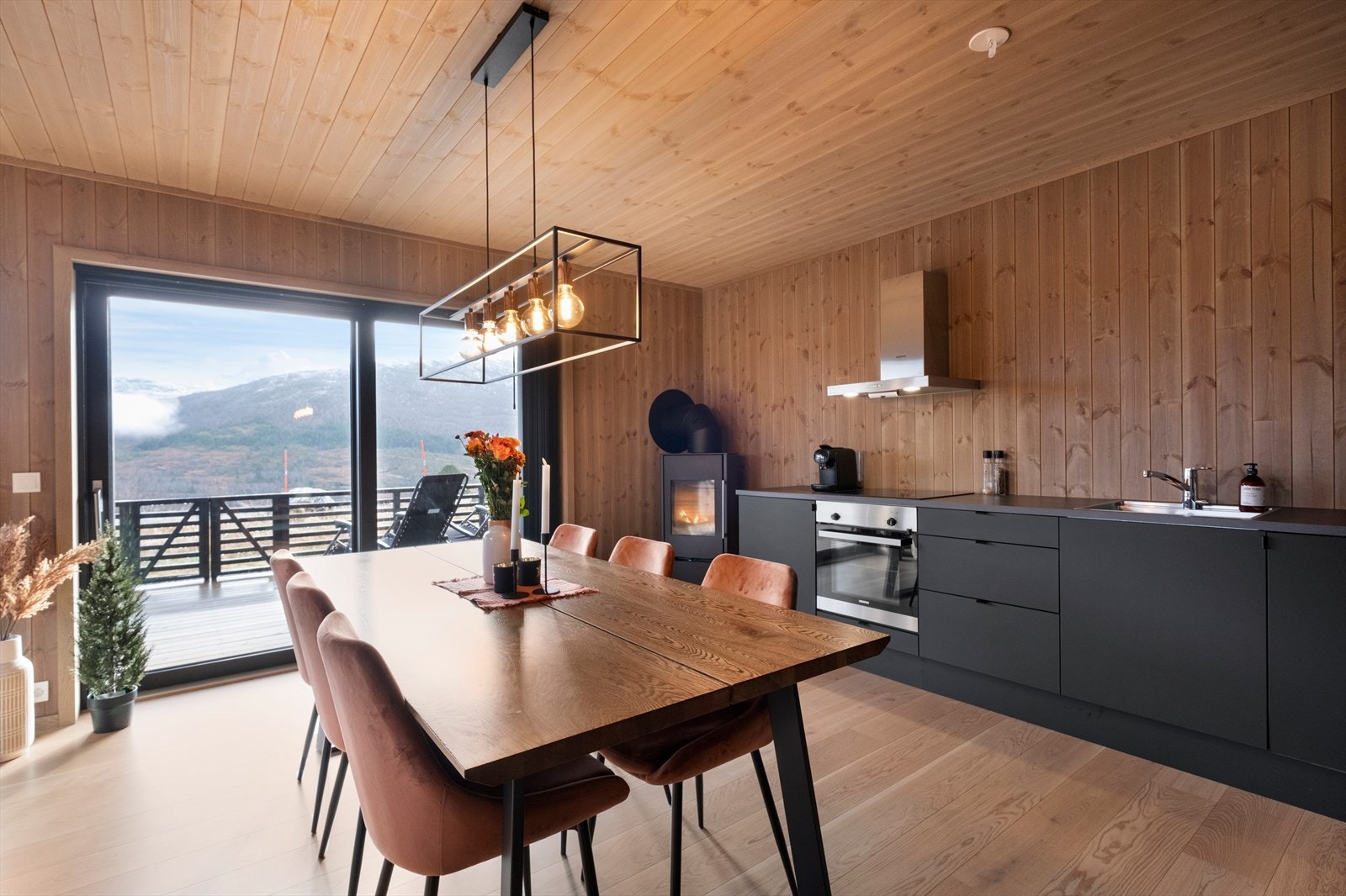 Store vinduer gir fantastisk utsikt mot fjellandskapet fra spiseområdet. Galleribilde
