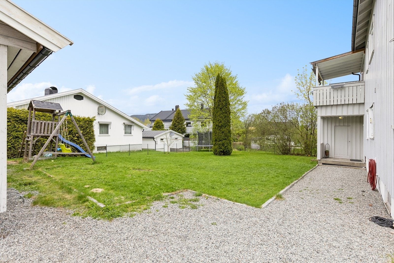 Romslig hage med plen og gruset gårdsplass med dobbelgarasje. Garasjen måler ca. 47 kvm og er oppført i 2016 - denne medfølger i sin helhet til leiligheten som selges. Galleribilde