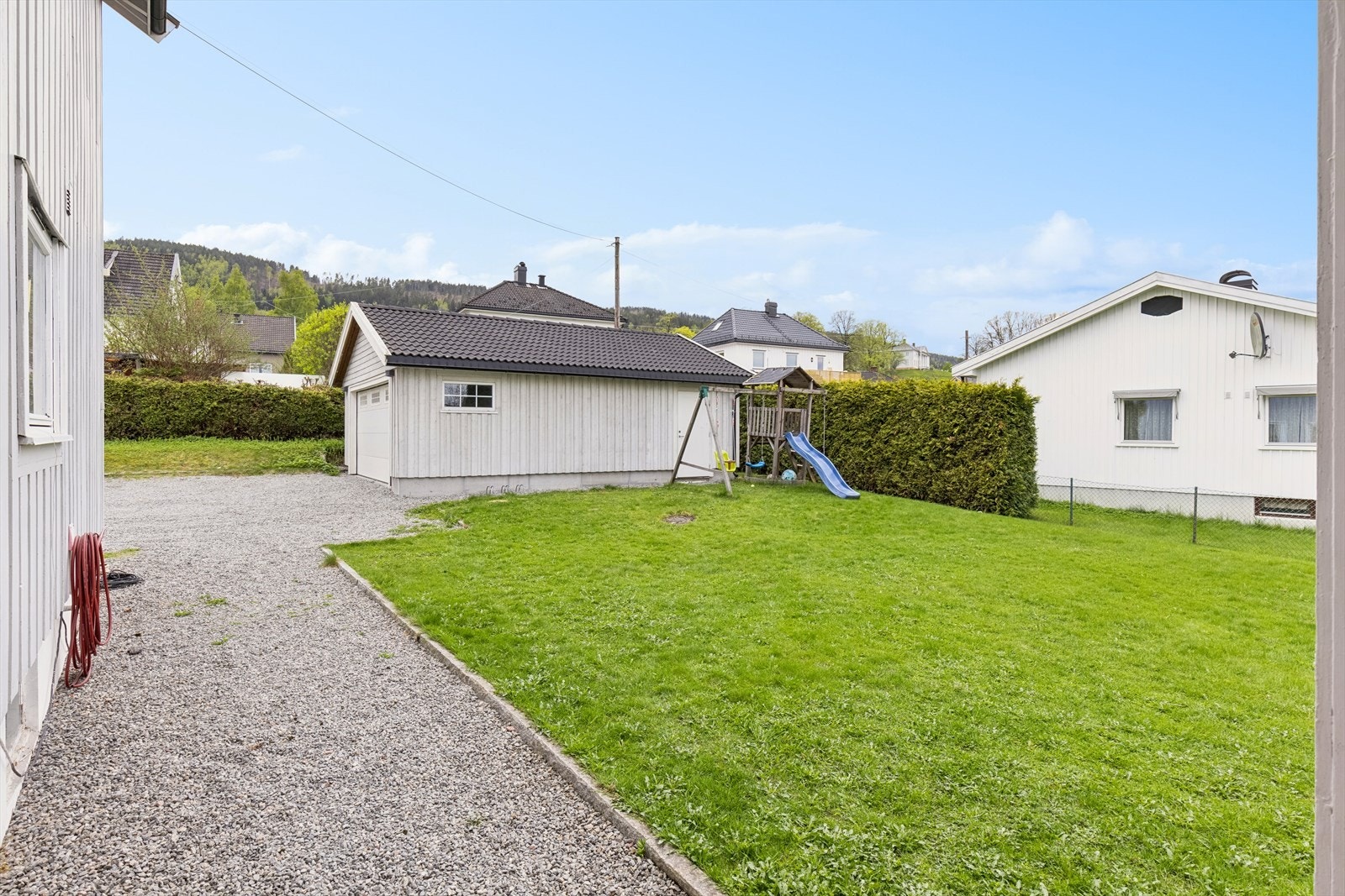 Inngangsparti og gruset gårdsplass mot dobbelgarasje Galleribilde