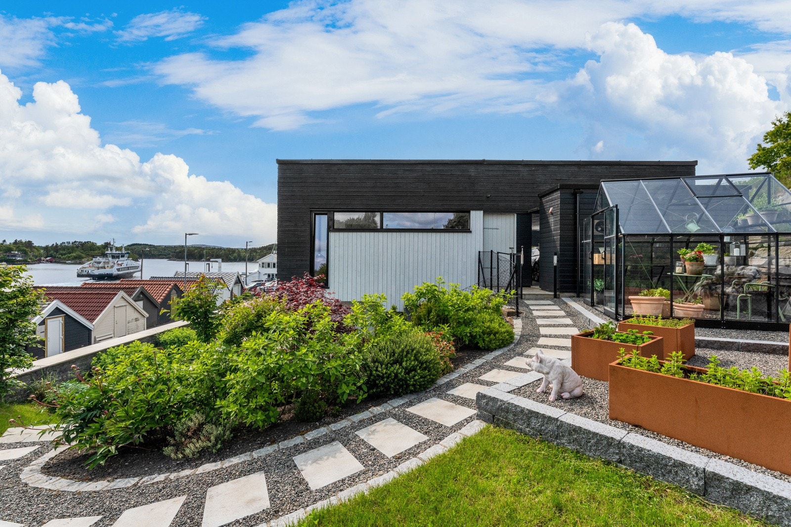 I hagen er det ogsy drivhus som både passer fint for selvdyrking og som vinterhage Galleribilde