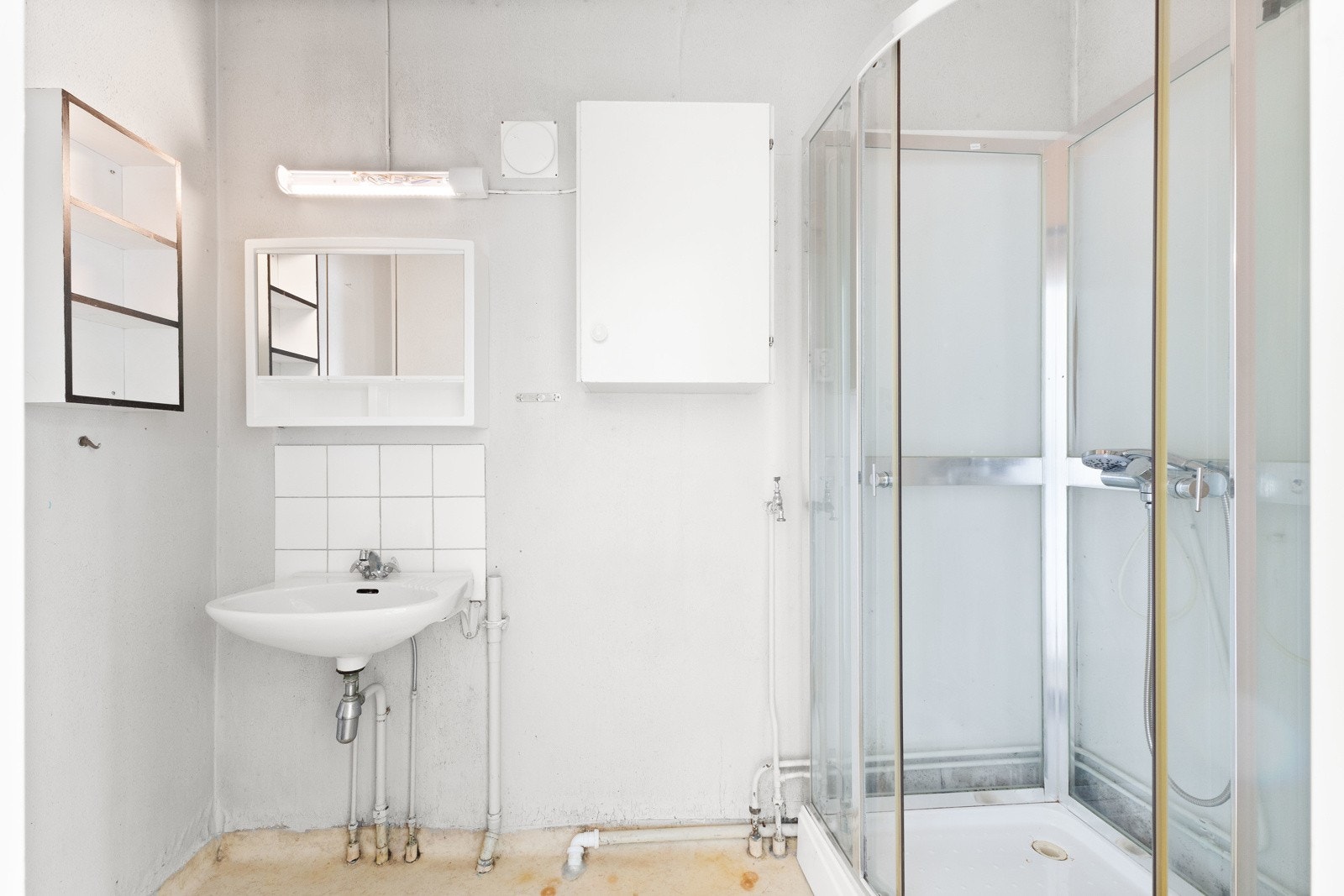 Badet har en smart planløsning med dusjkabinett, servant med oppbevaringsskap, speil, vegghengt belysning og toalett. Galleribilde