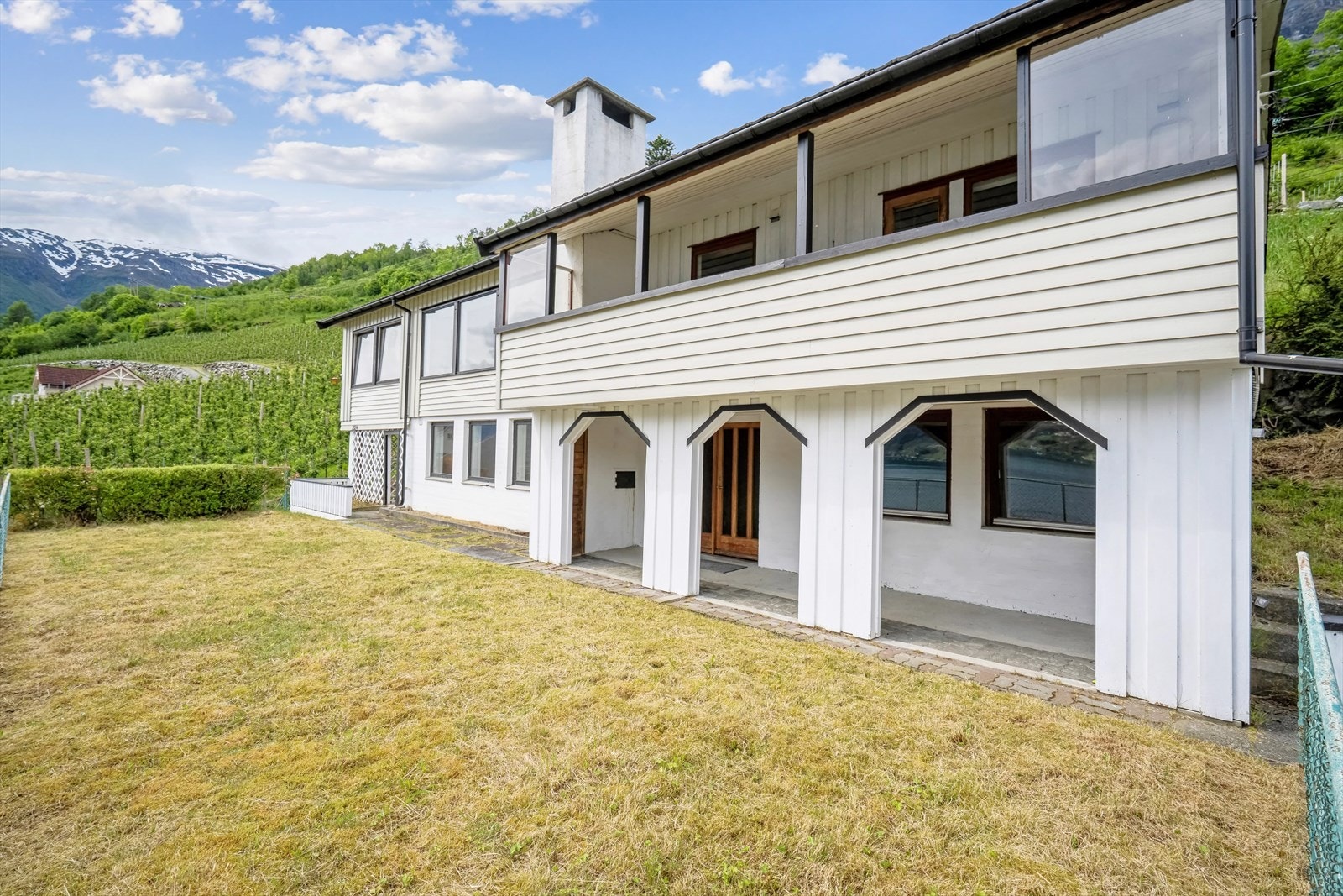 Flott gressplen over garasjen og stor overbygget altan Galleribilde