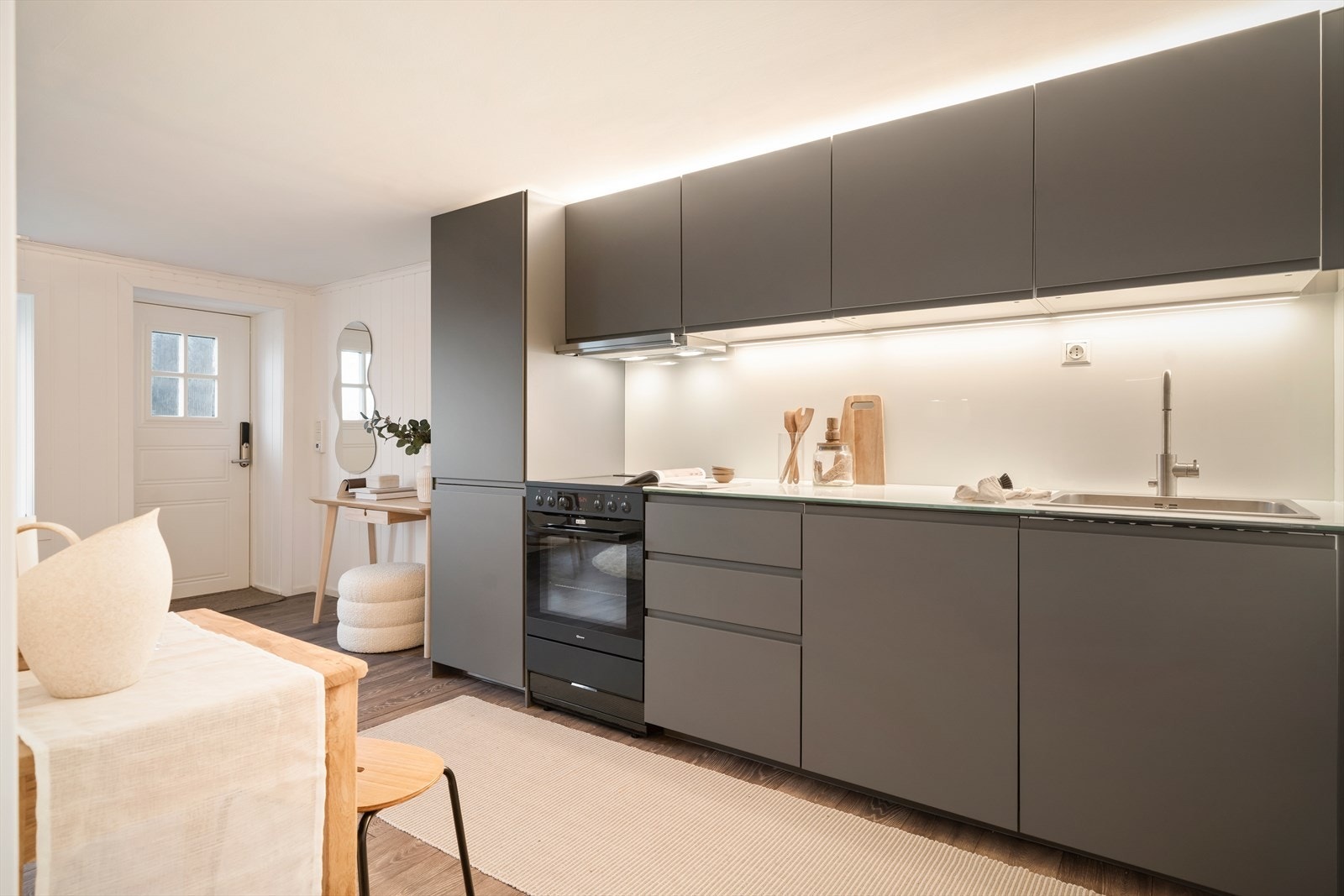 Stilrent IKEA-kjøkken fra 2025 med glatte fronter, glass-benkeplate og integrerte hvitevarer. Galleribilde